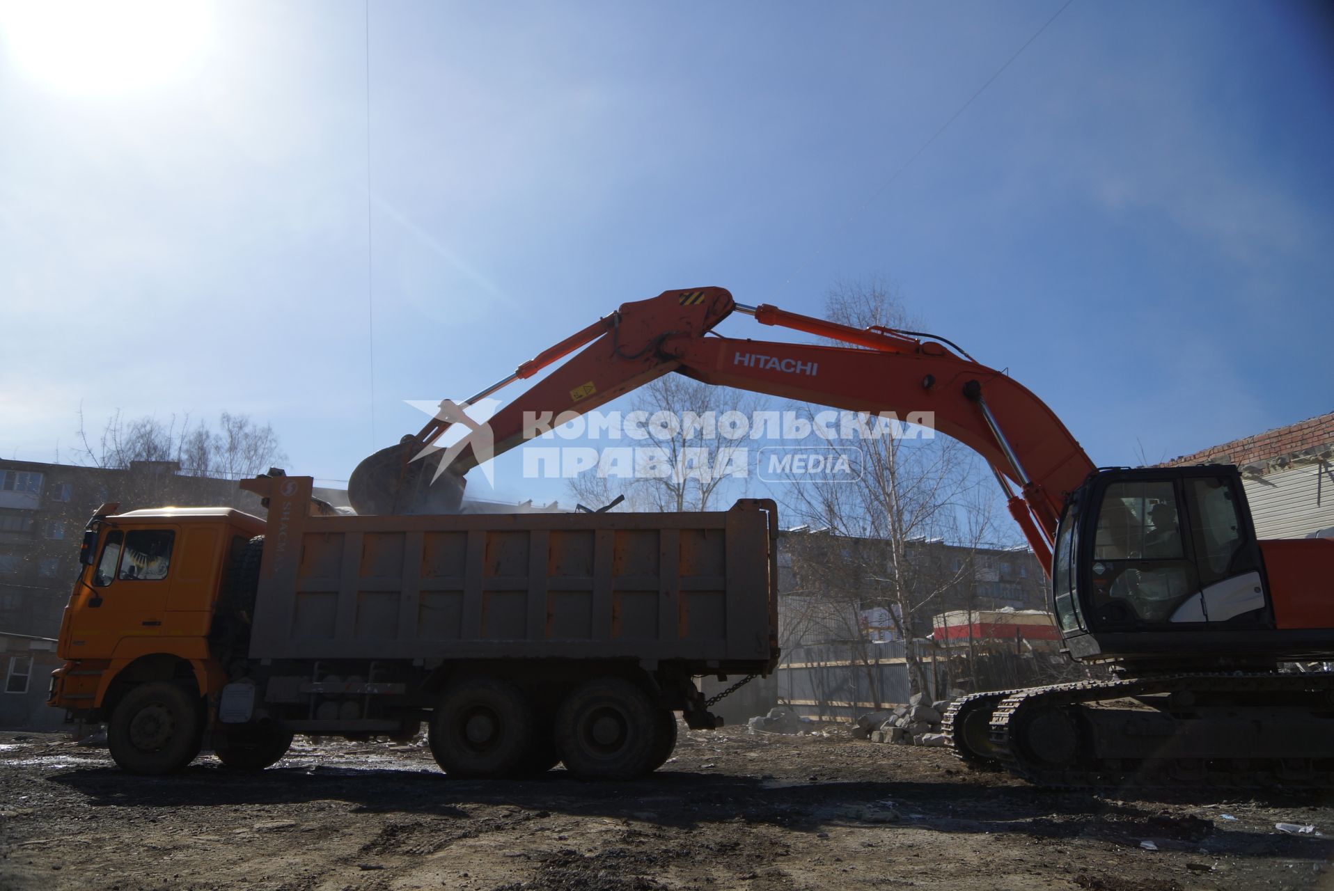 Екатеринбург. Принудительный снос незаконно построенного многоквартирного дома на земле для индивидуального строительства. Экскаватор собирает строительный мусор.