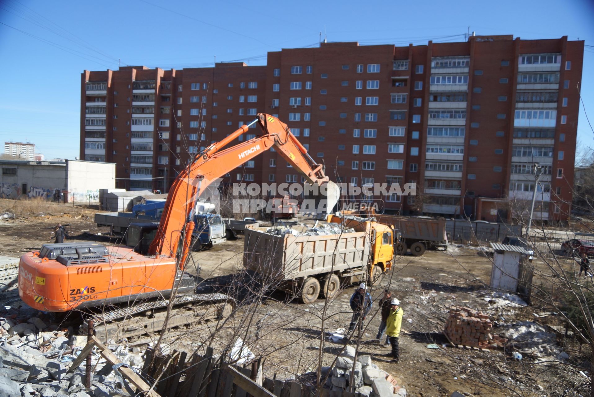 Екатеринбург. Принудительный снос незаконно построенного многоквартирного дома на земле для индивидуального строительства. Экскаватор собирает строительный мусор.