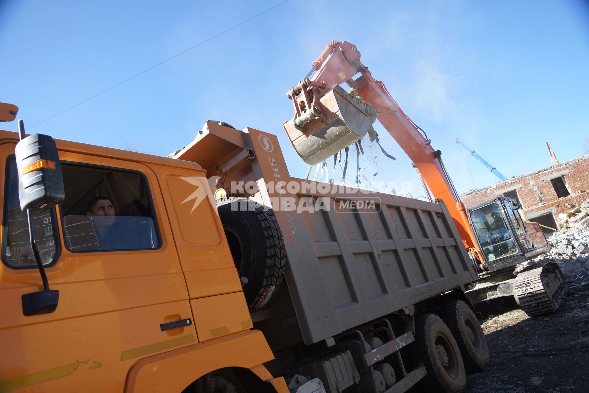 Екатеринбург. Принудительный снос незаконно построенного многоквартирного дома на земле для индивидуального строительства. Экскаватор собирает строительный мусор.