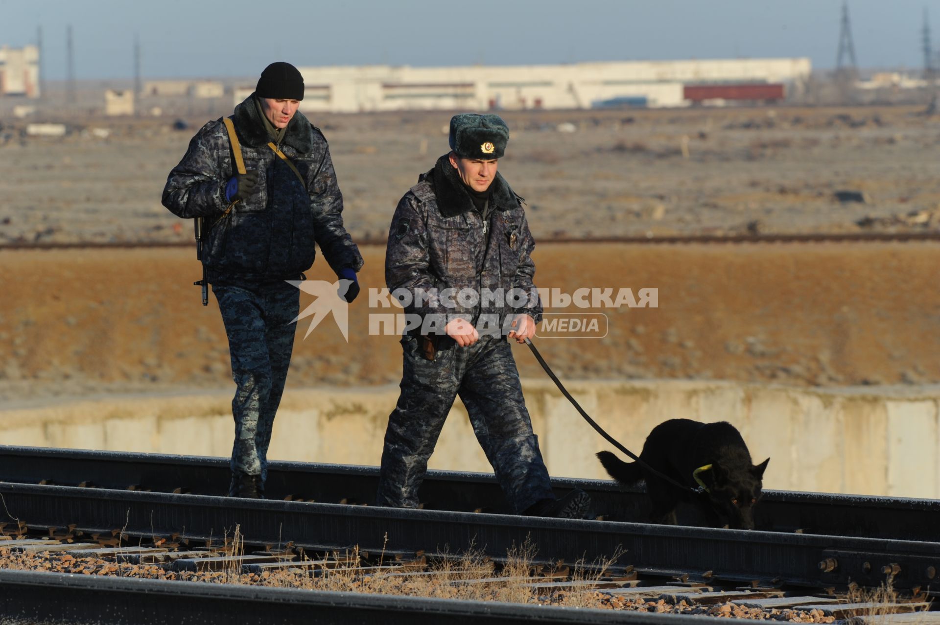 Космодром `Байконур`. Полицейские с собакой осматривают пути.