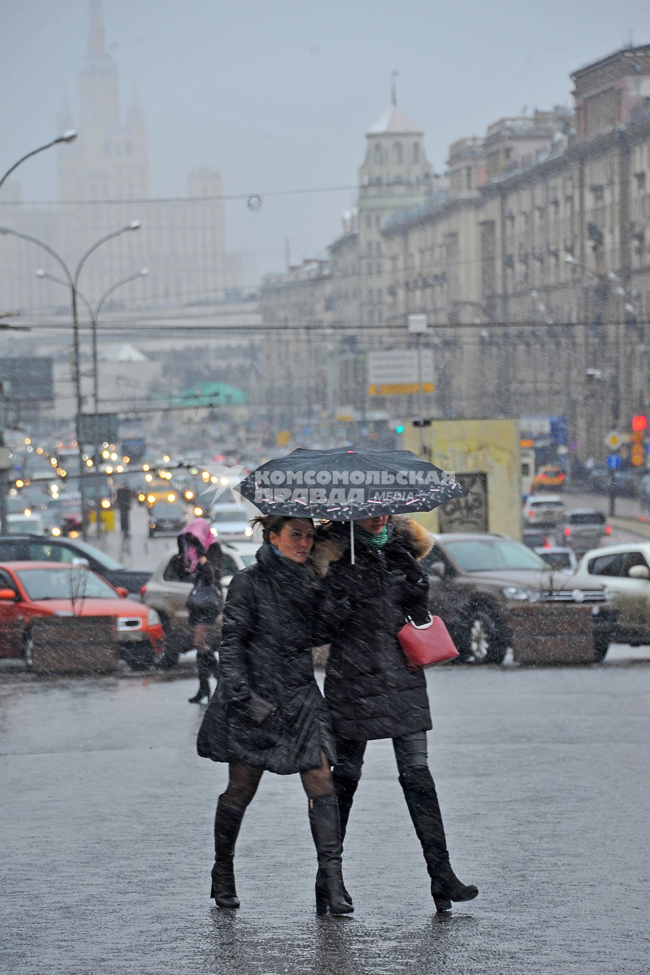 Снегопад в Москве.  Девушки идут под зонтом.