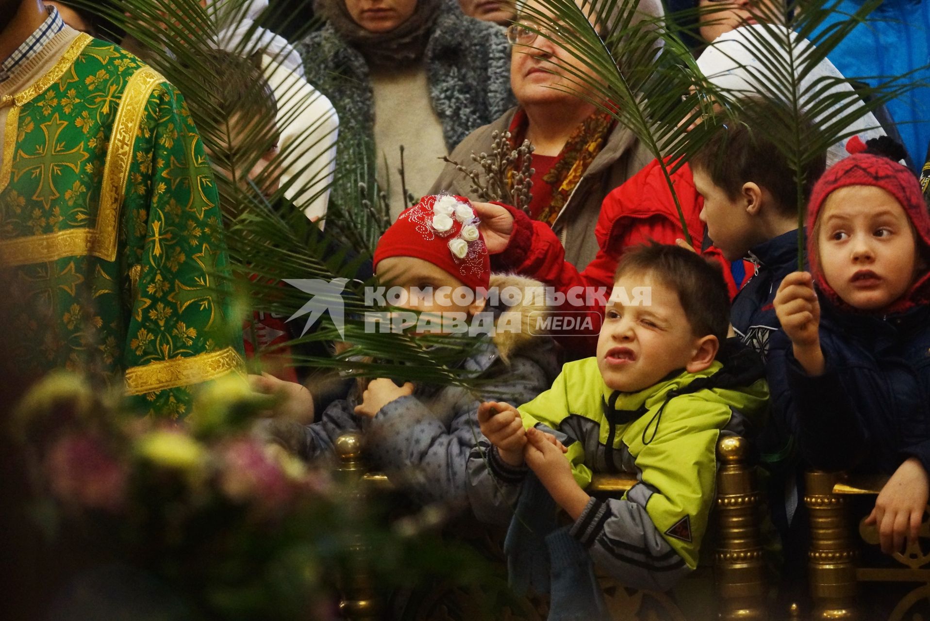 Мальчик \"стреляет\" из пальмовой ветви, скучая во время детской литургии в Свято-Троицком соборе. Вербное воскресенье. Екатеринбург