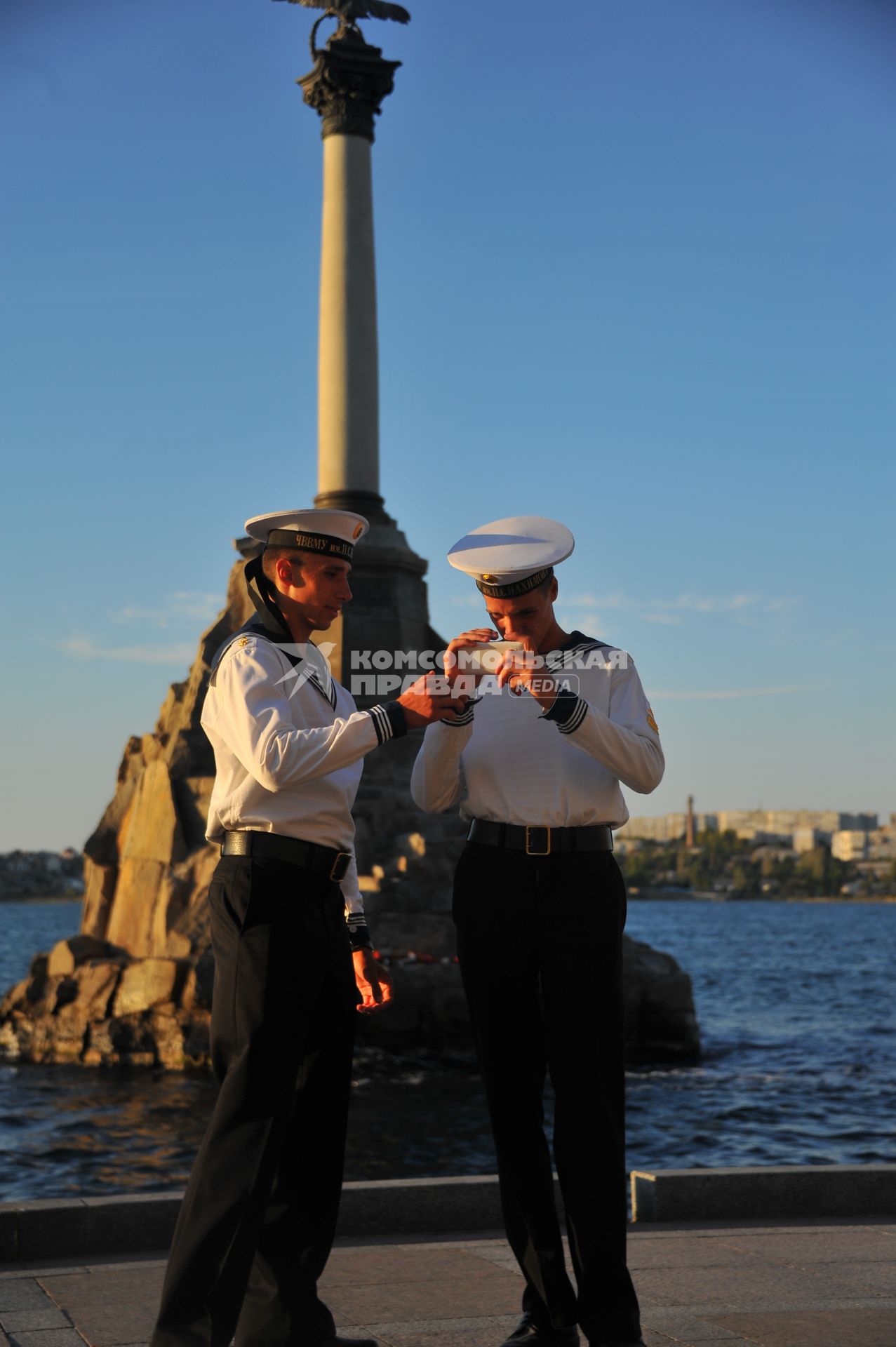 Севастополь. Учащиеся военно-морского училища имени П.С.Нахимова фотографируются на фоне памятника затопленным кораблям.