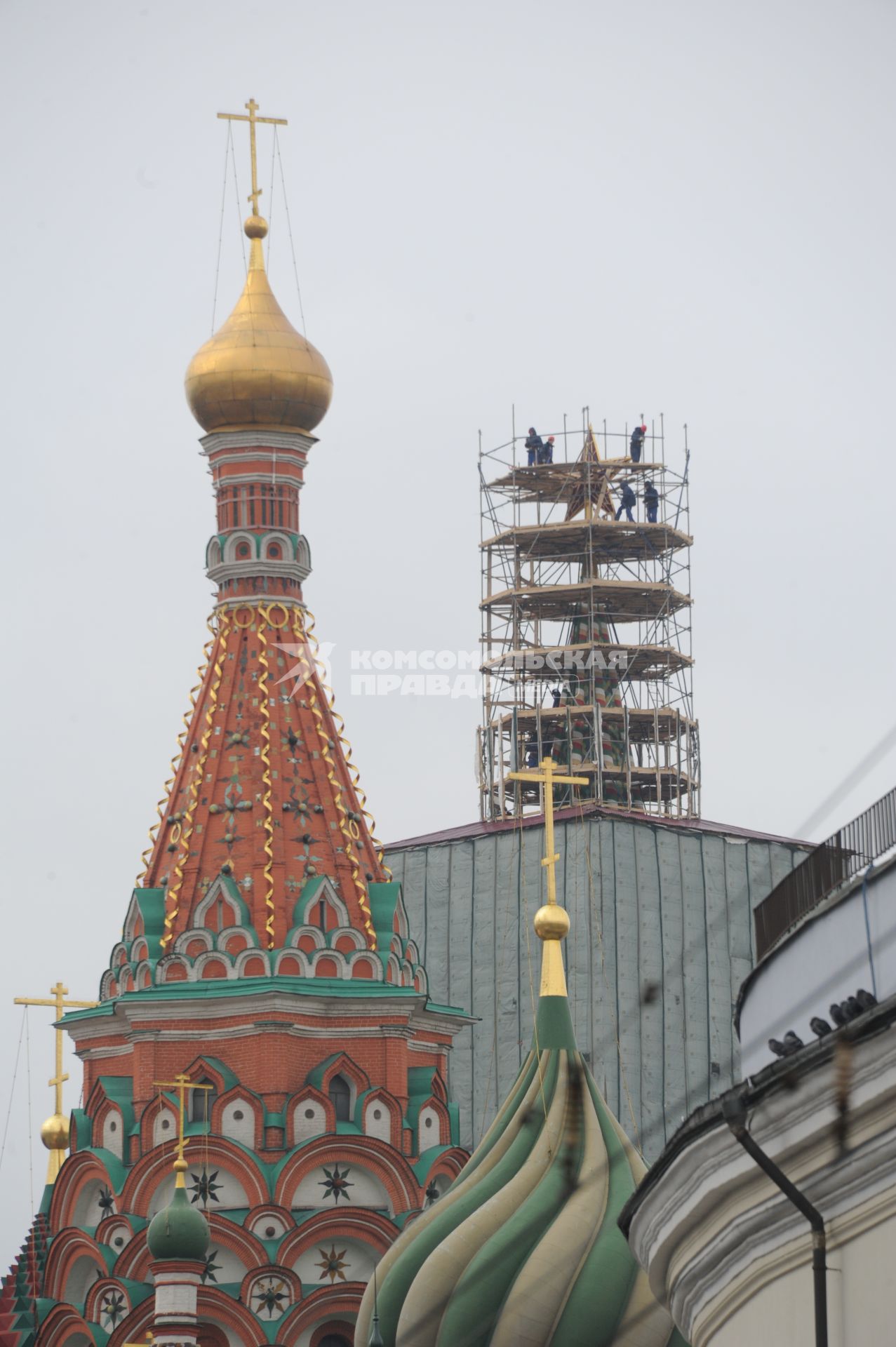 Демонтаж строительных лесов на Спасской башне московского Кремля в Москве.