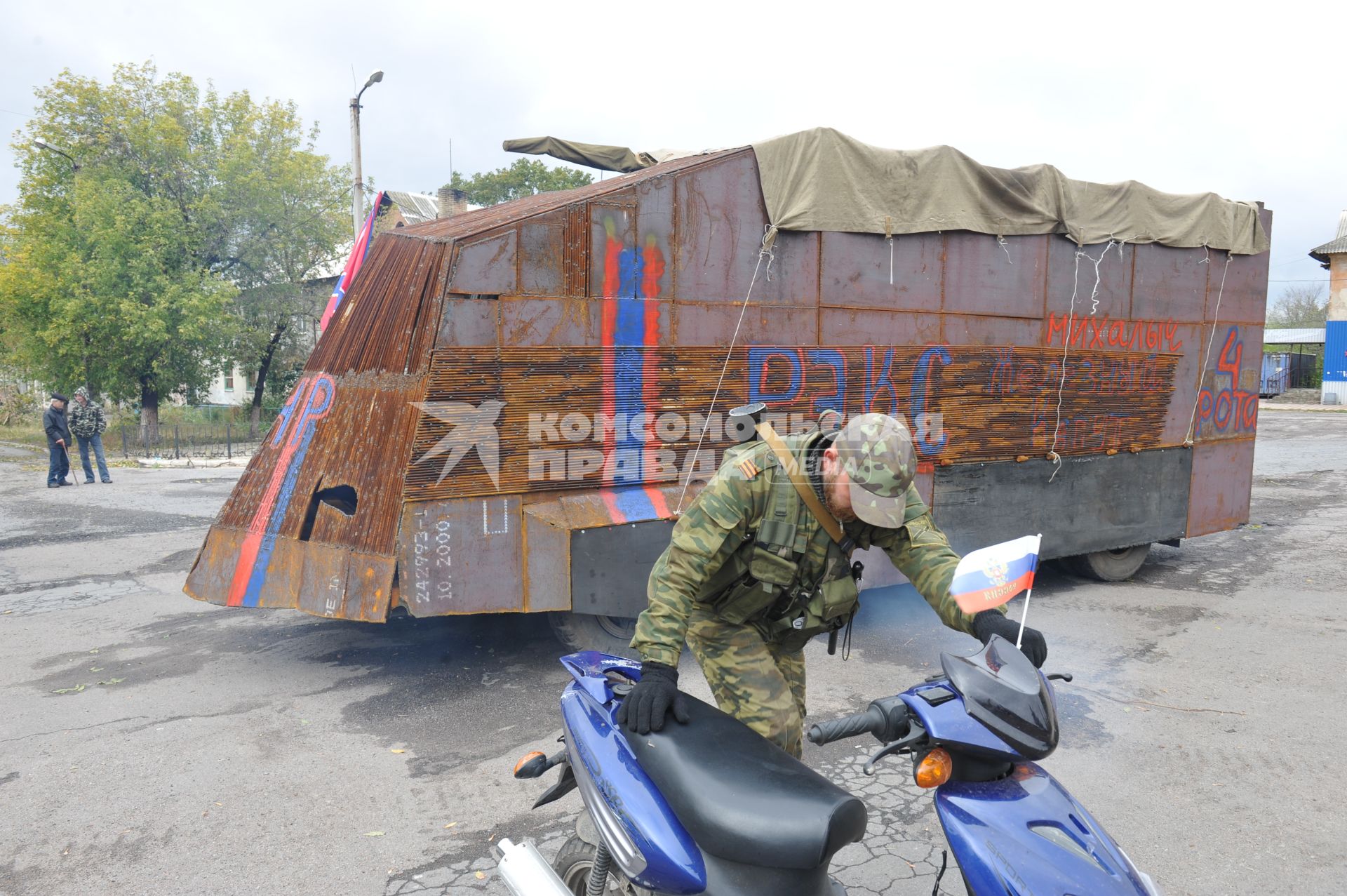 Украина. Донецкая область. п.Коммунар. Ополченец у бронемашины с надписью `4 рота Рэкс` на площади.