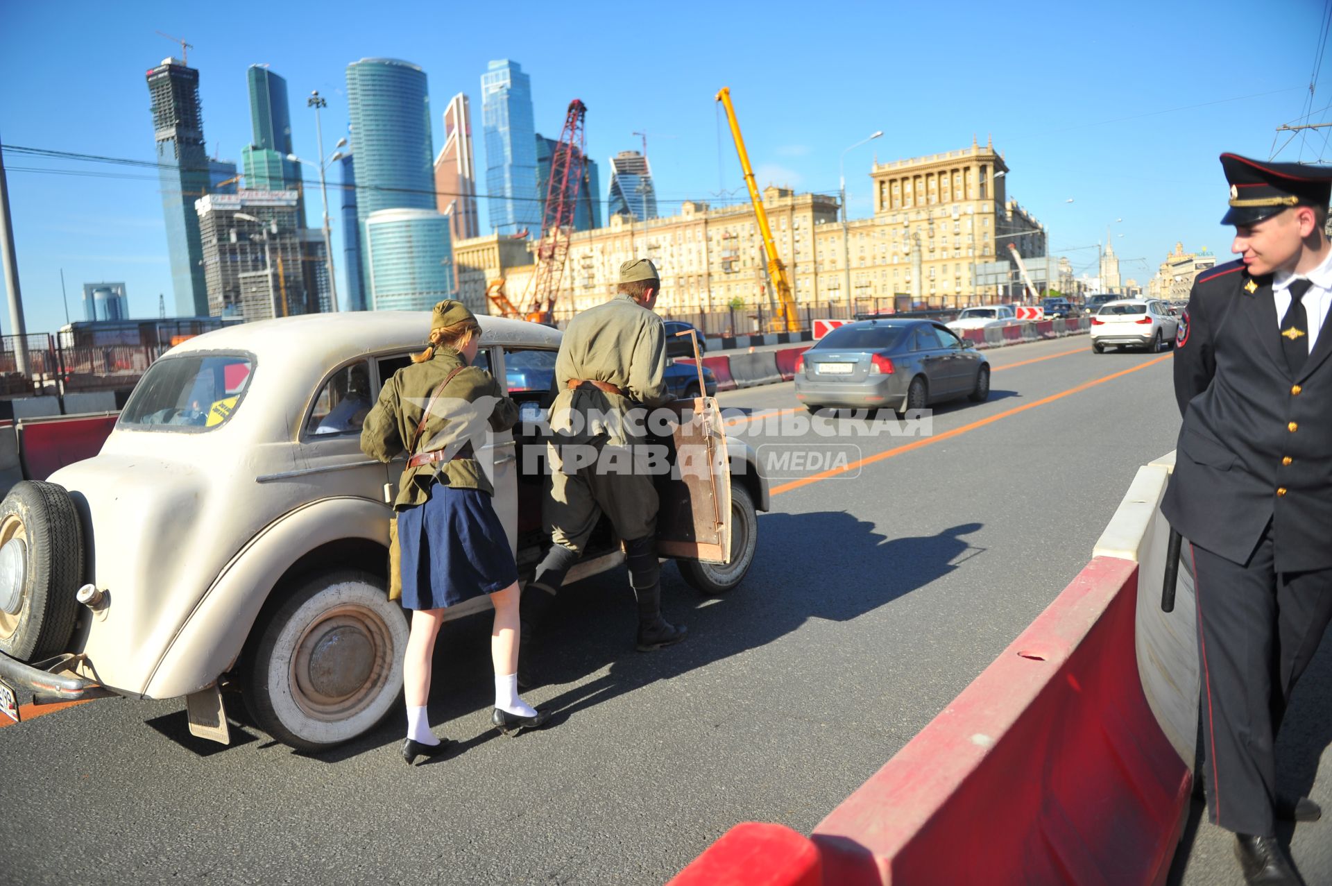 Москва. Молодые люди в военной форме времен ВОВ толкают ретро-автомобиль по Дорогомиловскому мосту во время праздничных мероприятий, посвященных 69-й годовщине Победы в Великой Отечественной войне на Поклонной горе.