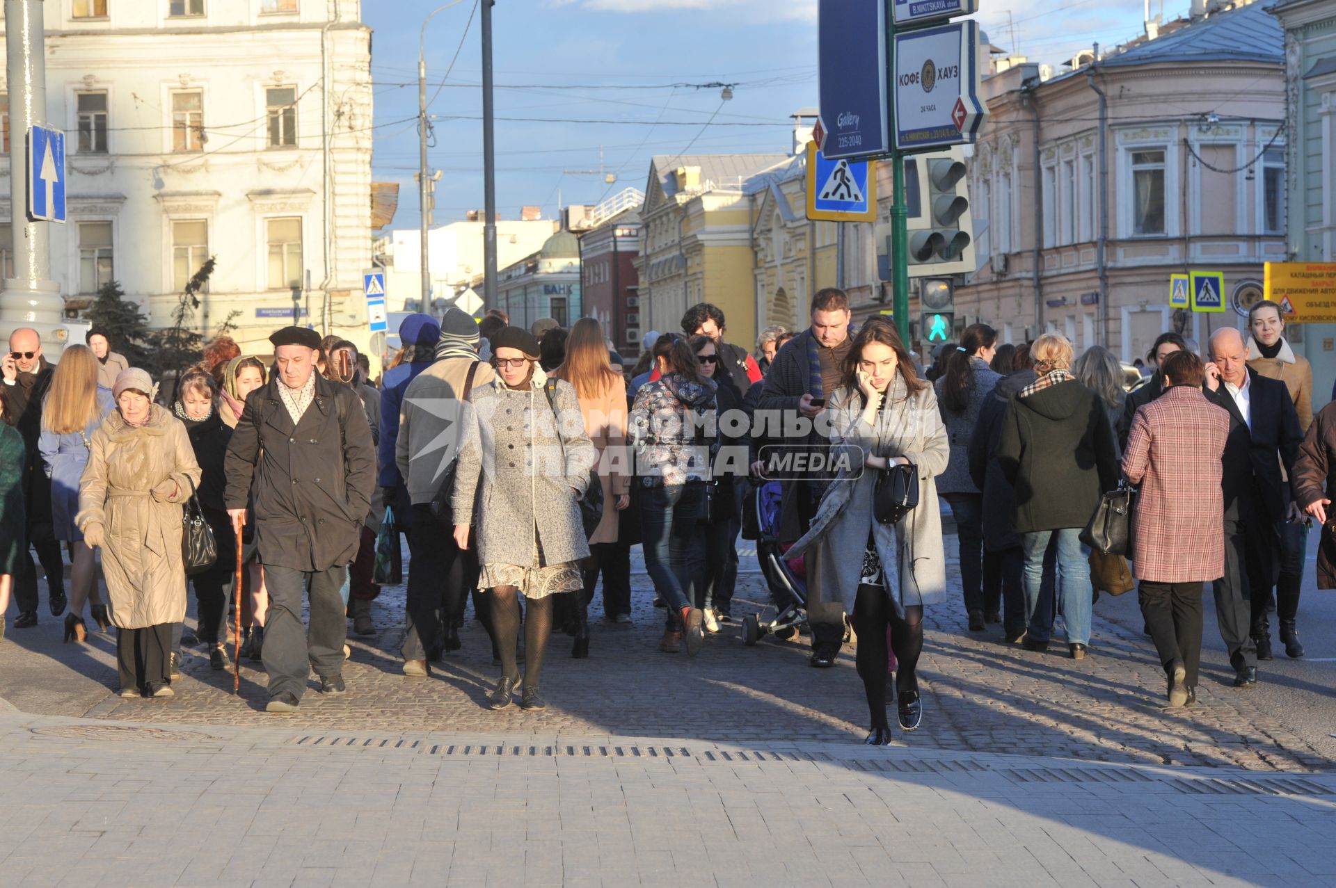 Люди идет по пешеходному переходу на площади Никитские ворота в Москве.