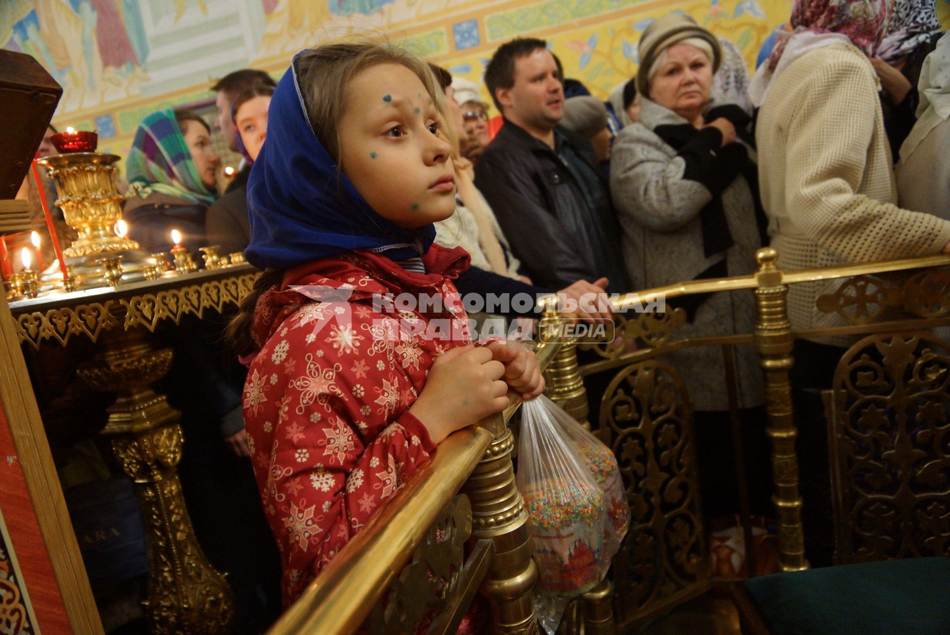 девочка болеющая ветрянкой, с пятнами зеленки, держит мешок с куличами для освящения во время Пасхальной службы в Свято-Троицком соборе. Екатеринбург