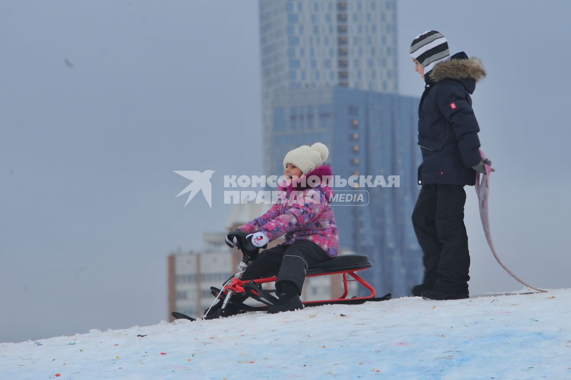 Москва. Девочка с санками на снежной горке в Парке Победы.