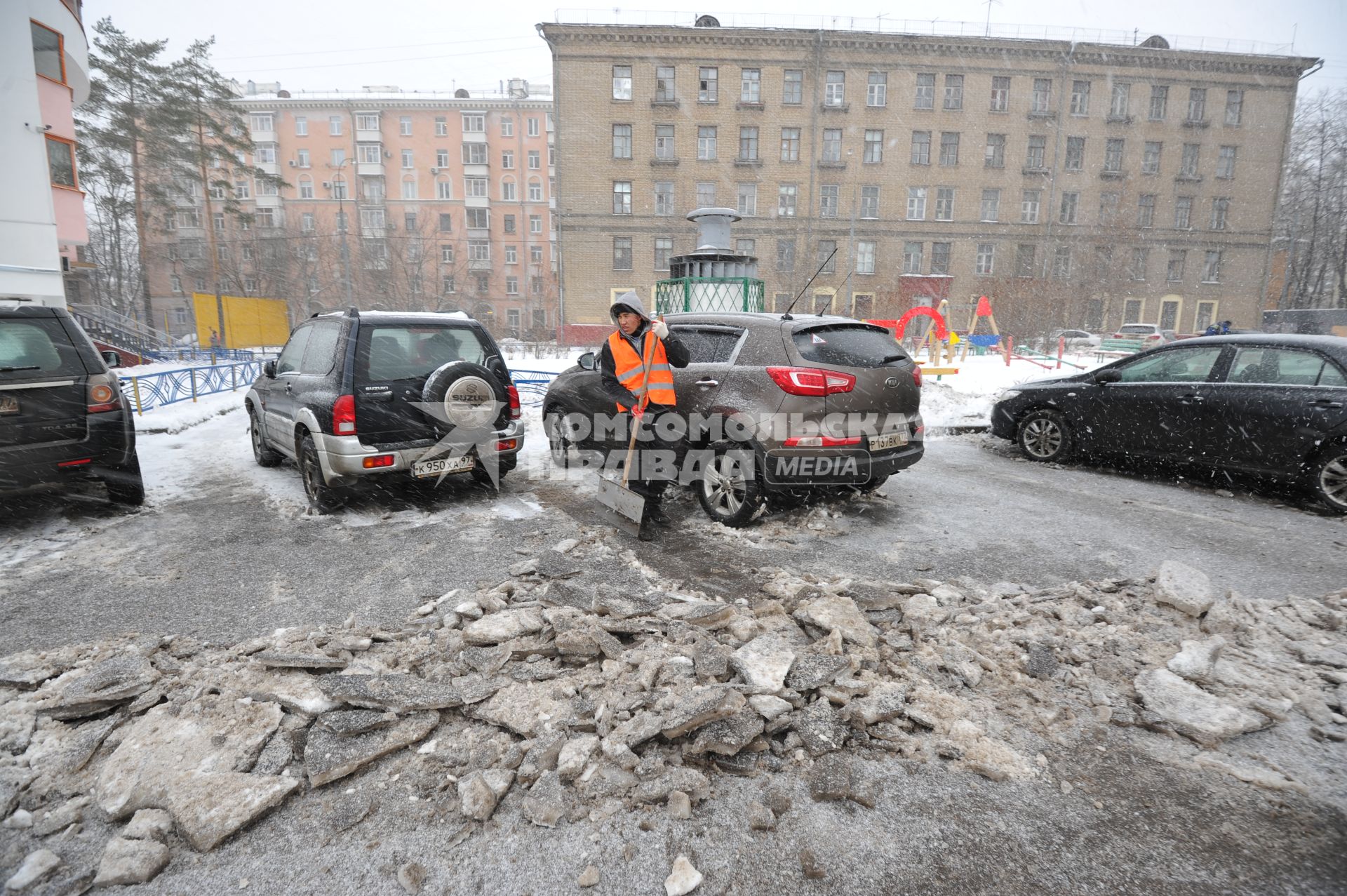 Москва. Дворник ГБУ `Жилищник` района Покровское-Стрешнево убирает лопатой сбитую наледь с асфальта.