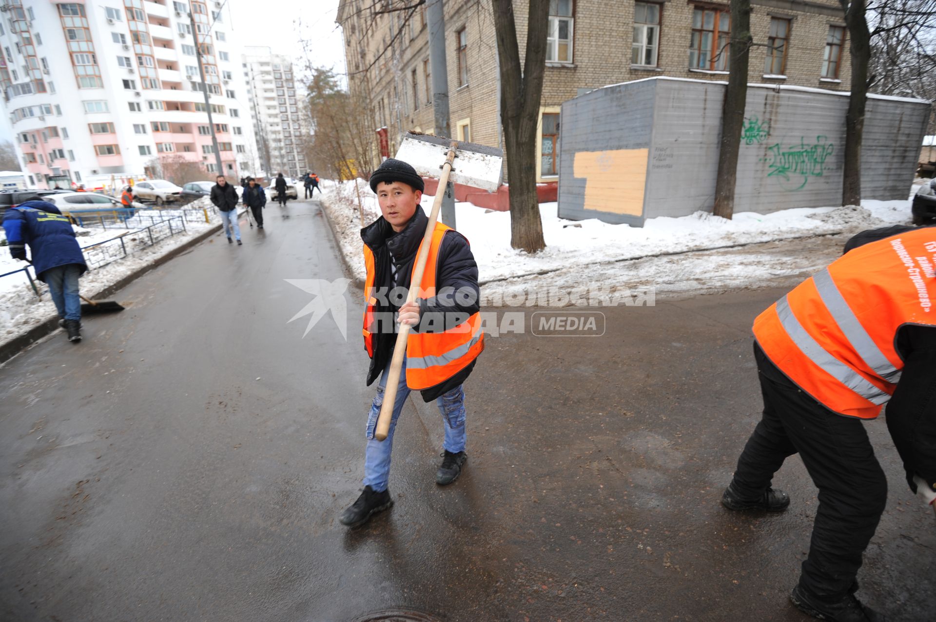 Москва. Дворник ГБУ `Жилищник` района Покровское-Стрешнево убирает лопатой сбитую наледь с асфальта.