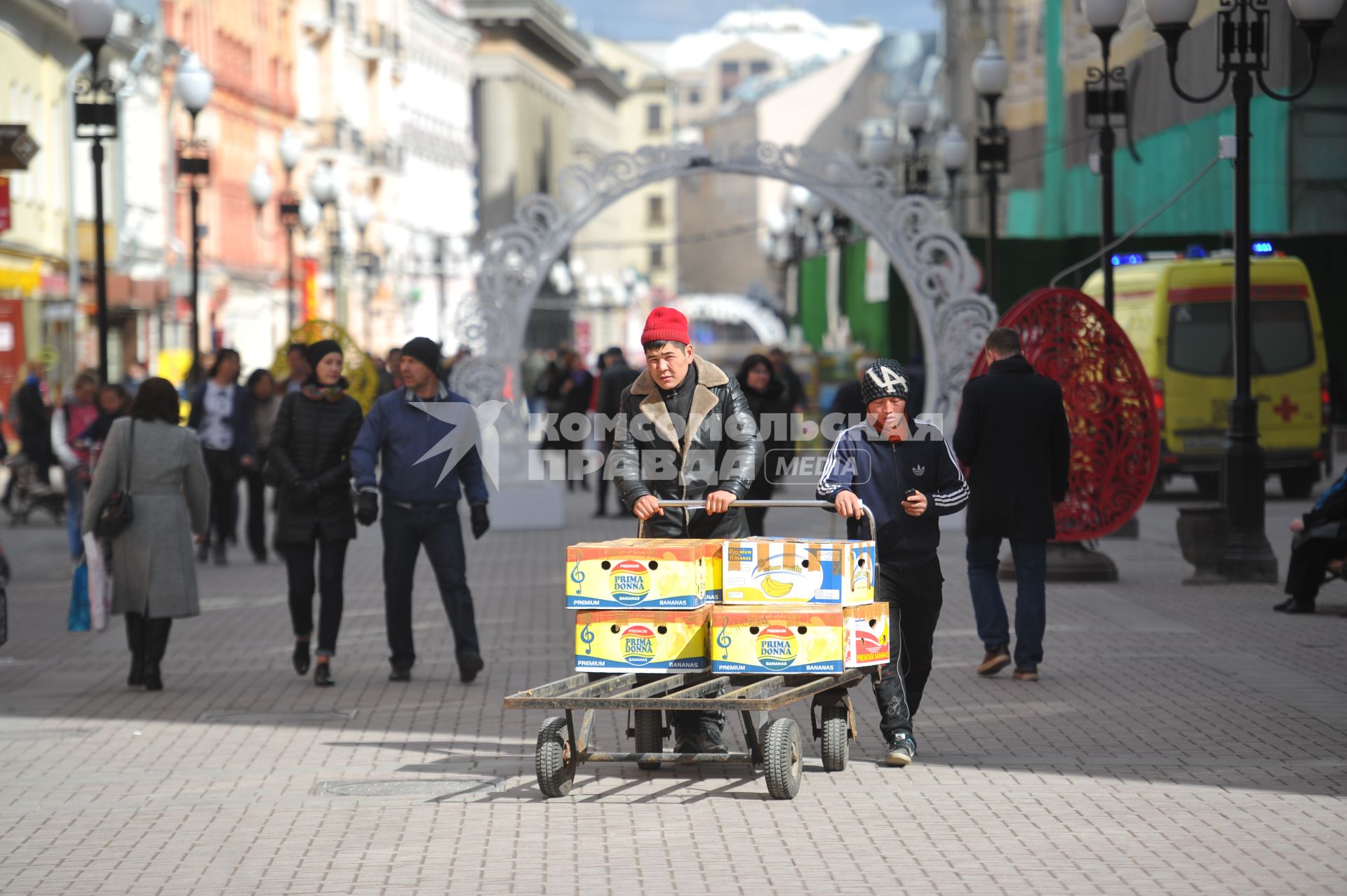Мужчины катят тележку с коробками  на Старом Арбате в Москве.