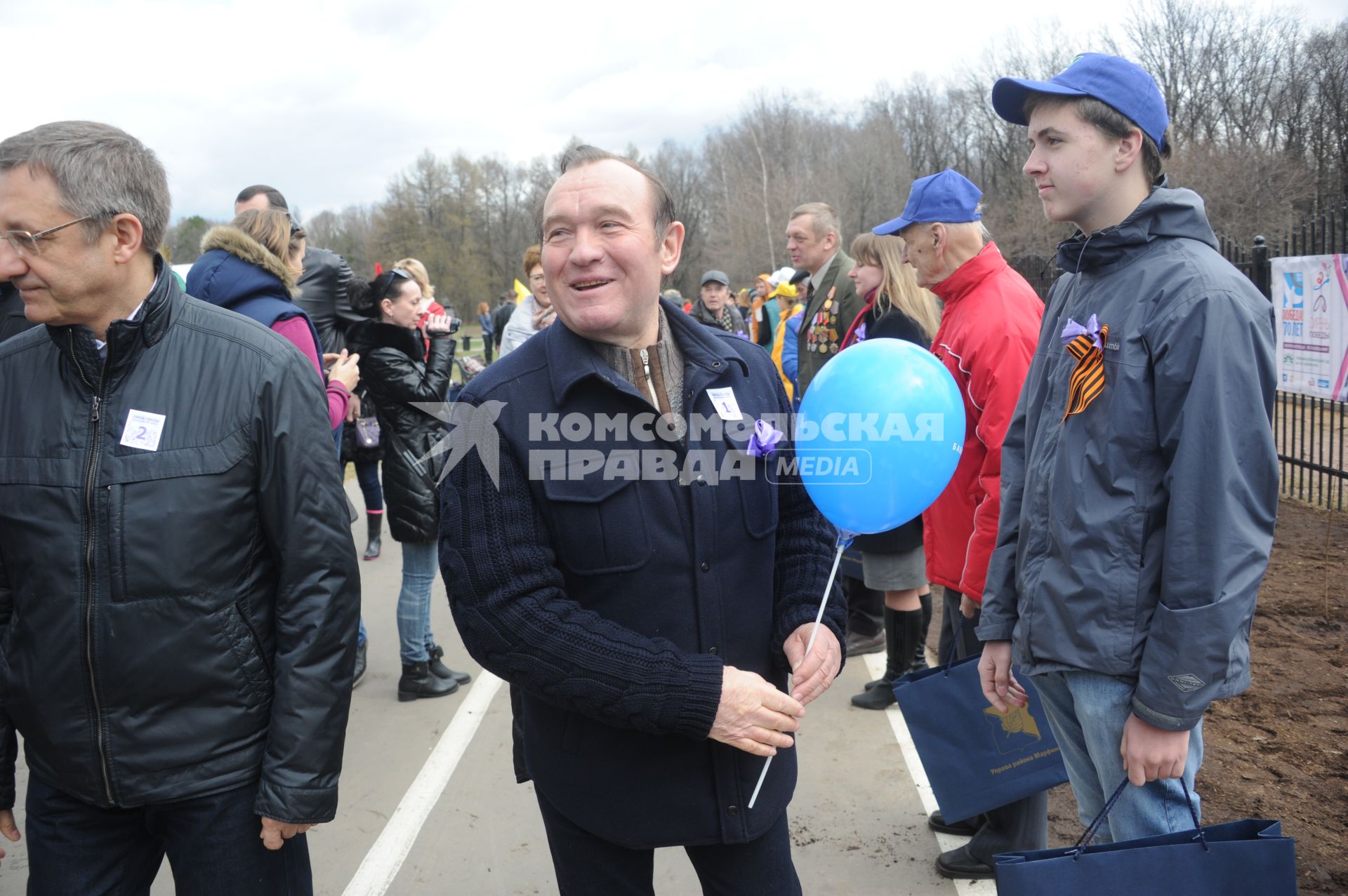 Заместитель мэра Москвы по вопросам ЖКХ Петр Бирюков (в центре) во время акции `Сирень Победы` в Ботаническом саду в Москве .