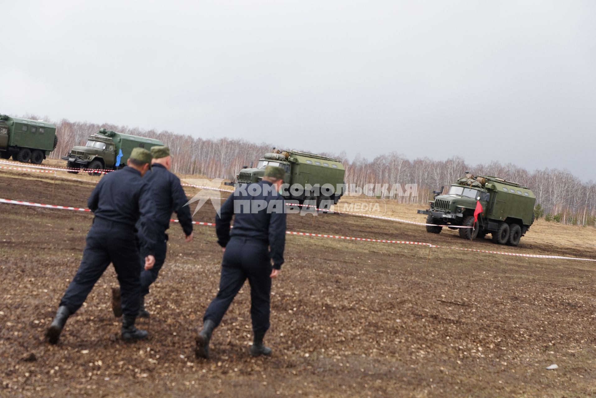 Учатники идт к машинам.  Международный конкурс \"Мастер автобронетанковой техники\", проходящий на Чебаркульском полигоне в Челябинской области