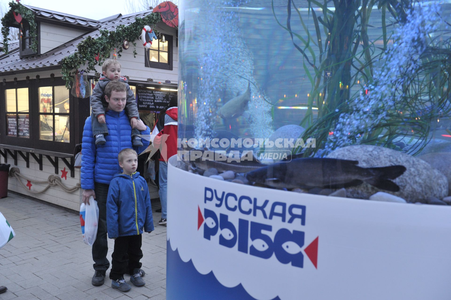 Прохожие рассматривают гигантский аквариум на Тверском бульваре, установленный в рамках фестиваля `Рыбная неделя` в Москве.