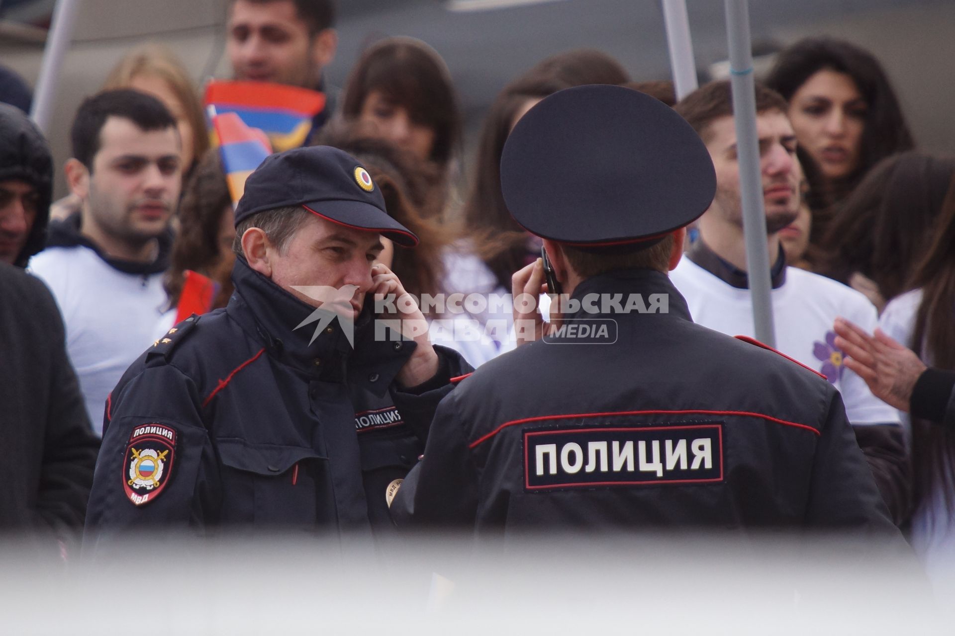 Полицейские говорят по телефону Шествие в память 100-летней годовщины геноцида армян войсками Османской империи. Церковь святого Карапета в Екатеринбурге