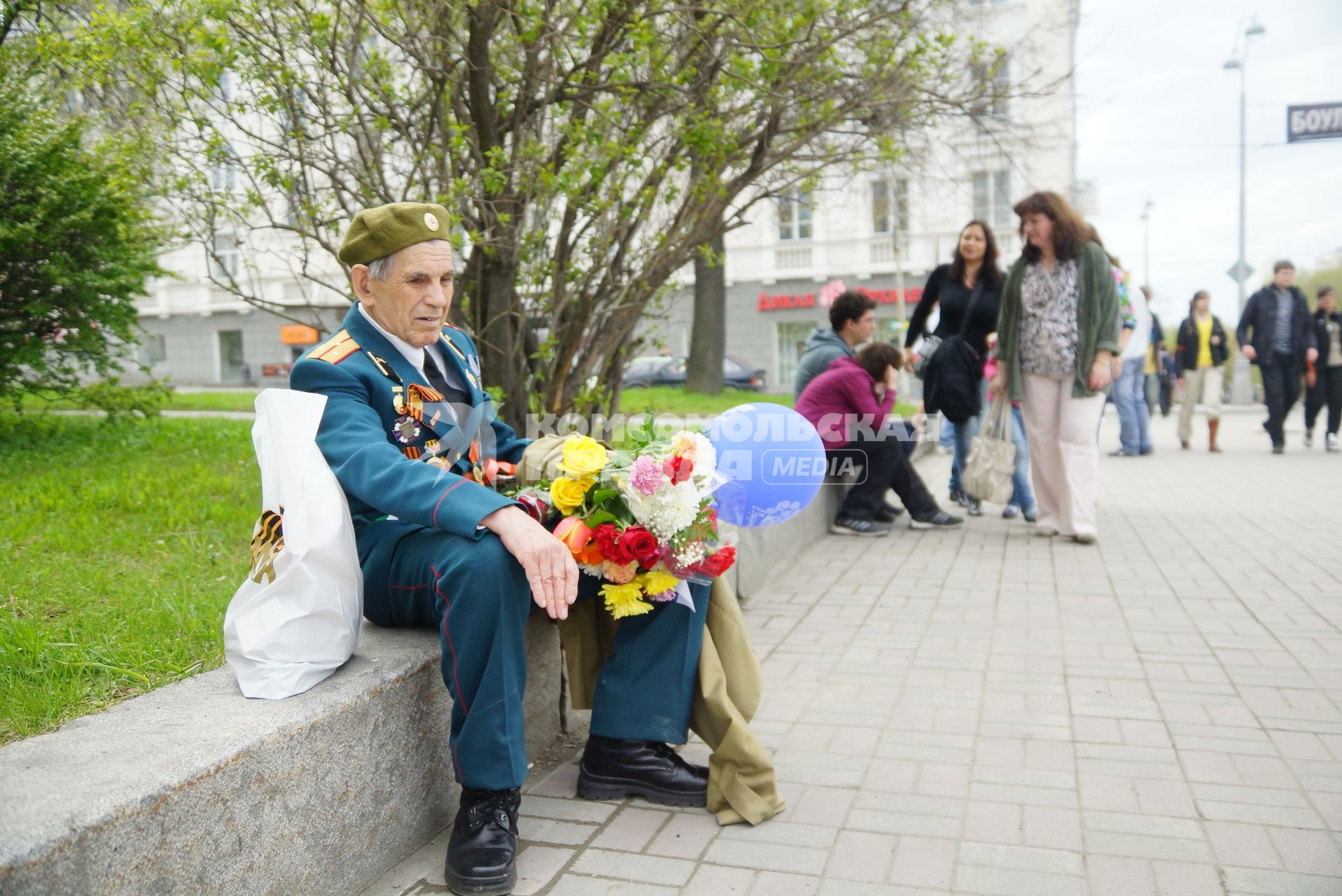 Ветеран в парадной форме с медалями и орденами, сидит на поребрике, во время празднования дня победы. Екатеринбург
