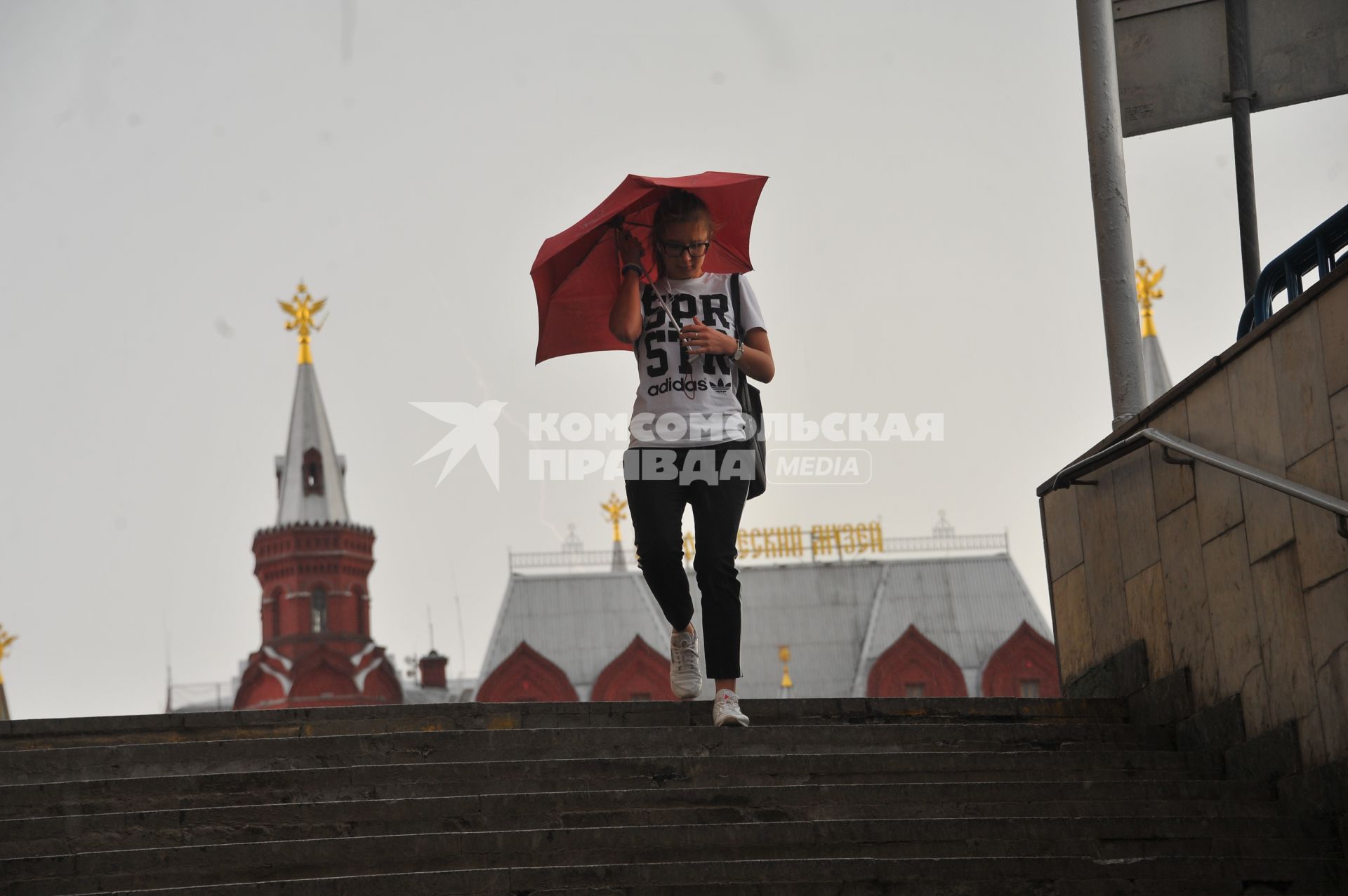 Москва.  Девушка с зонтом у станции метро `Охотный ряд` во время  дождя.