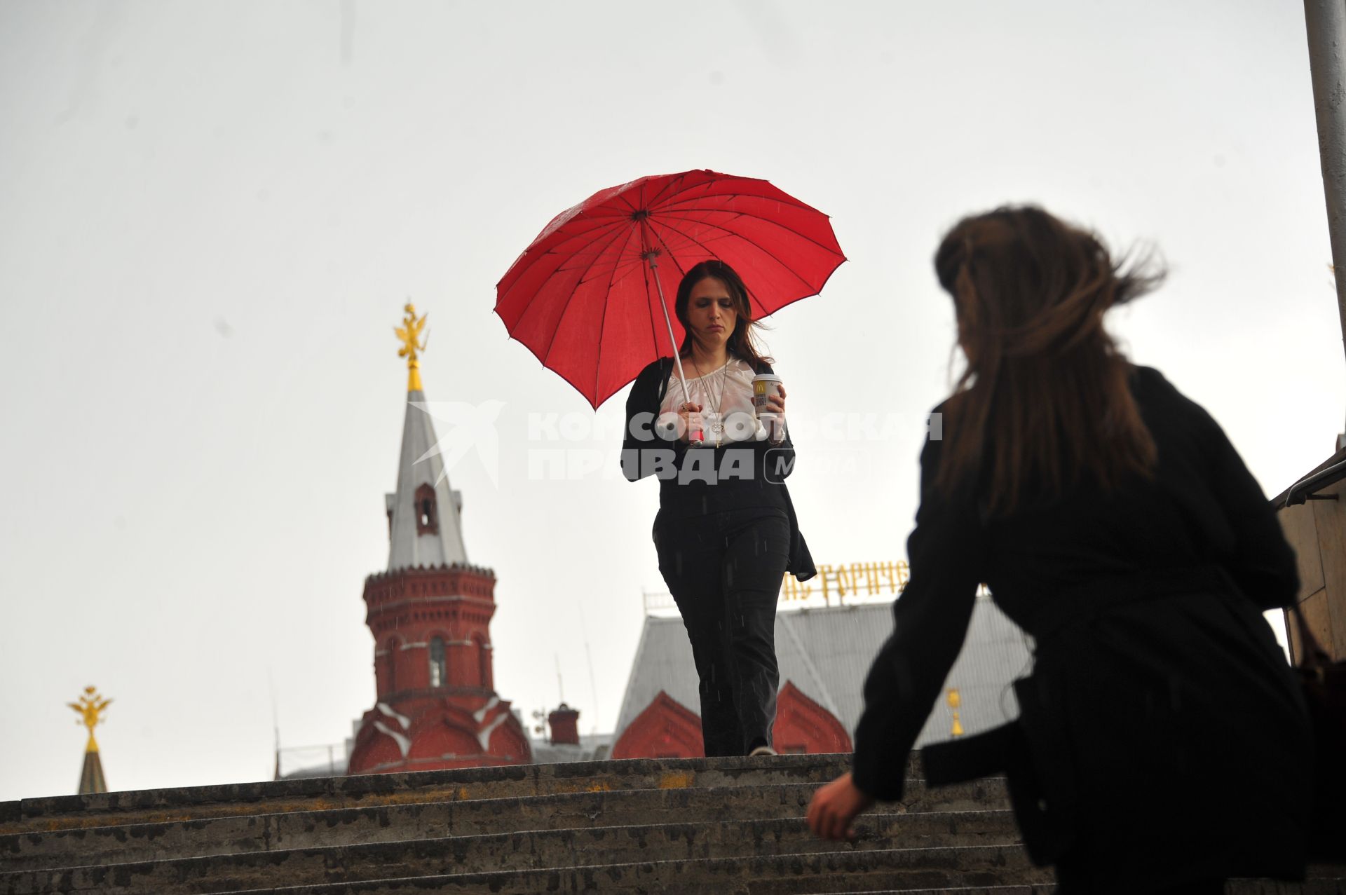 Москва.  Девушка с зонтом у станции метро `Охотный ряд` во время  дождя.