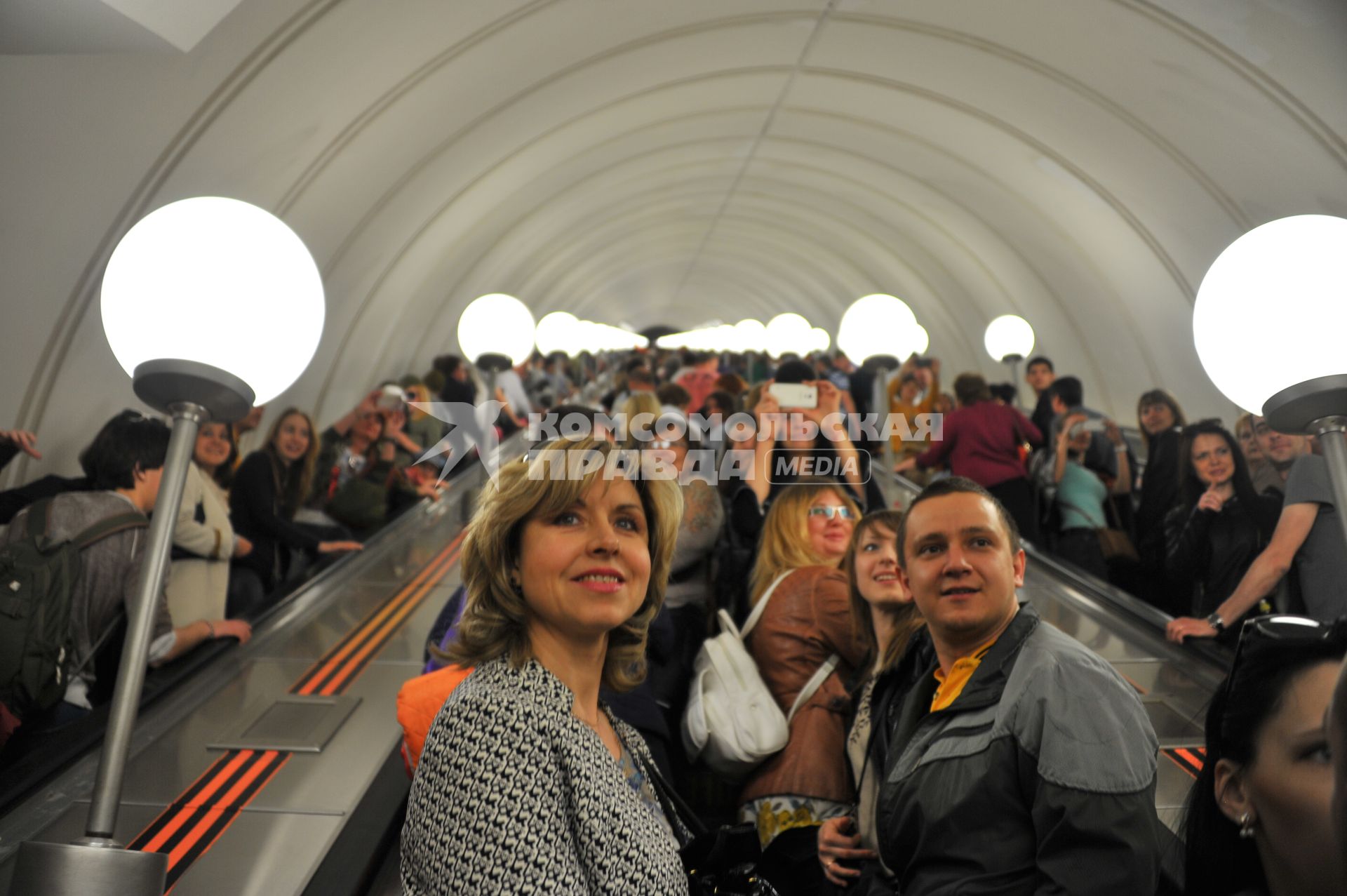 Празднования Дня Победы в Москве. Люди поднимаются по эскалатору на станции метро `Парк Победы`.