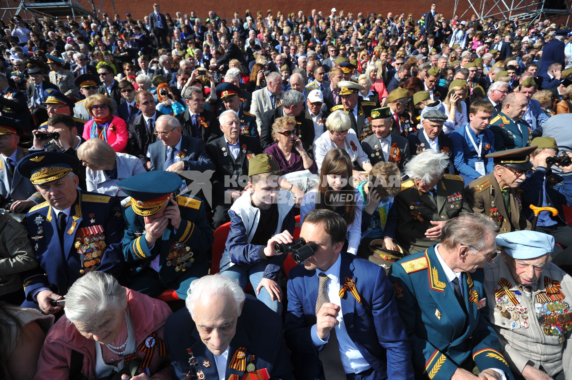 Москва. Люди наблюдают за военным парадом на Красной площади, в честь 70-летия Победы в Великой Отечественной войне.