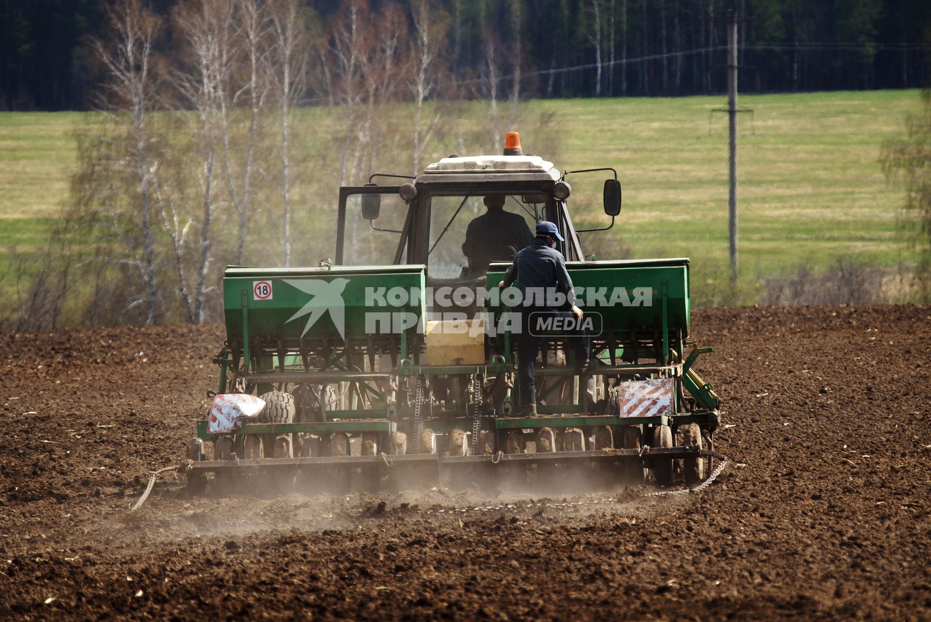 Трактор в поле, во время сева картофеля. Сельскохозяйственный производственный кооператив «Битимский». Свердловская область