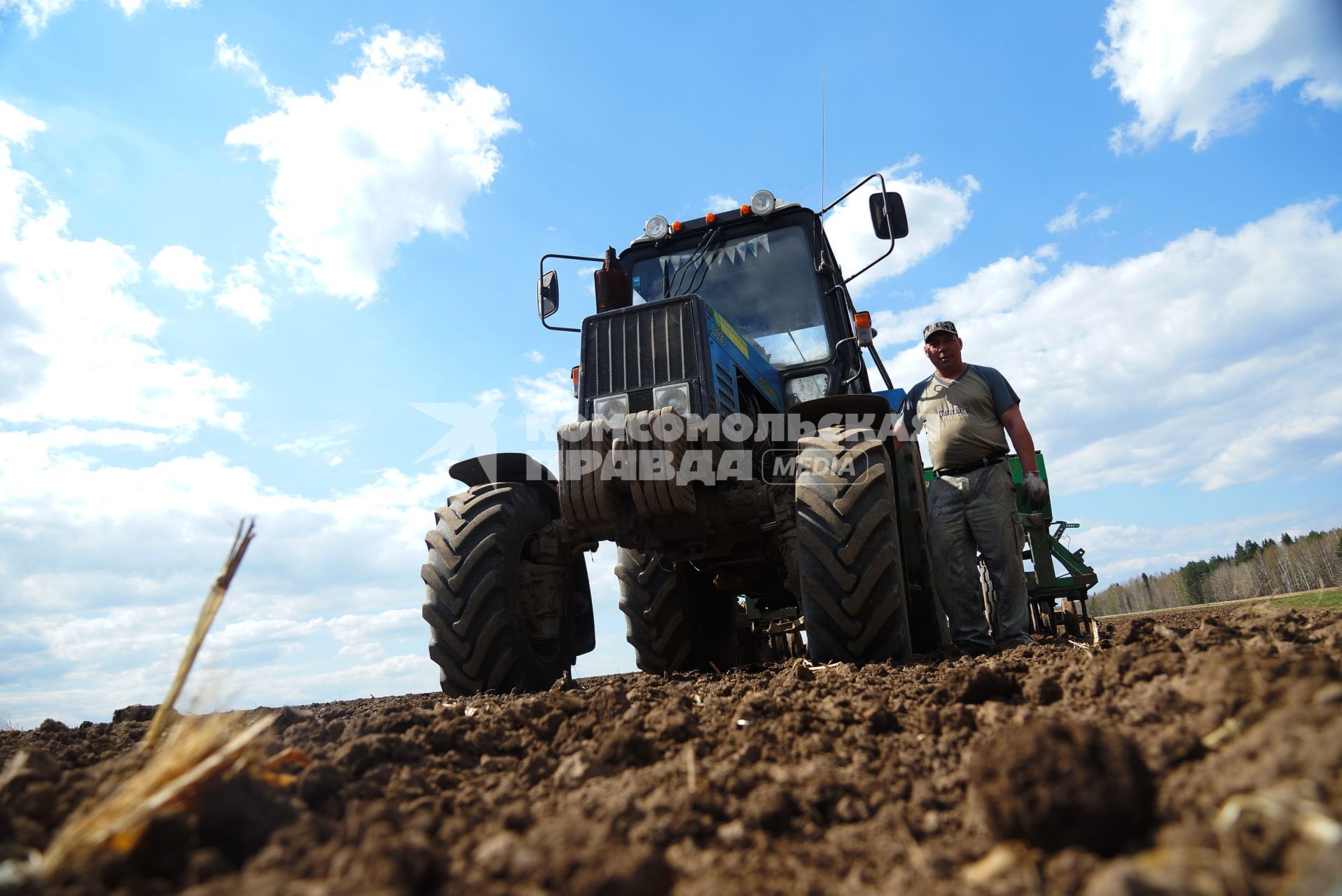 Тракторист стоит у своего трактора, во время сева картофеля. Сельскохозяйственный производственный кооператив «Битимский». Свердловская область
