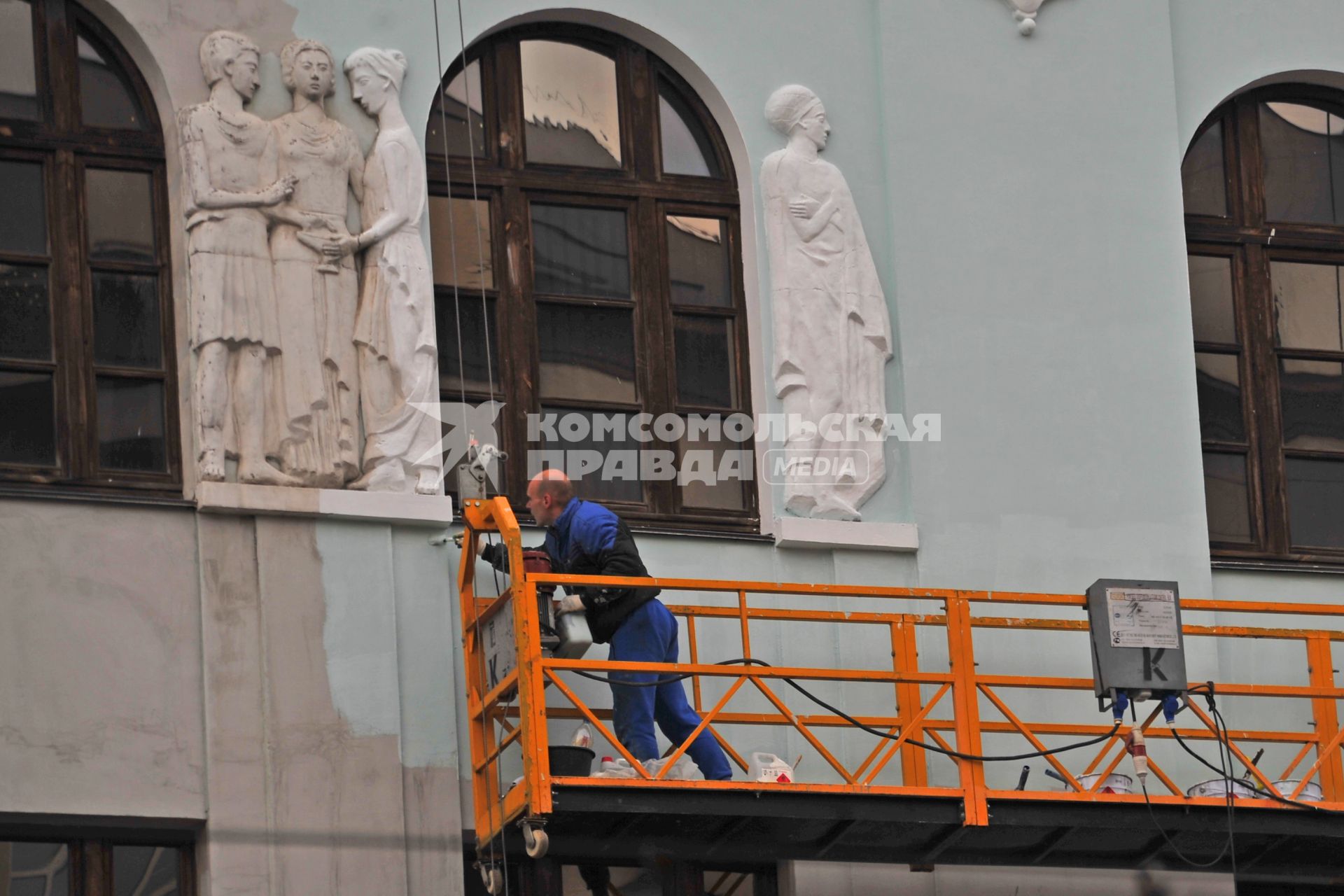 Москва. Мужчина реставрирует фасад здания на Преображенской площади.