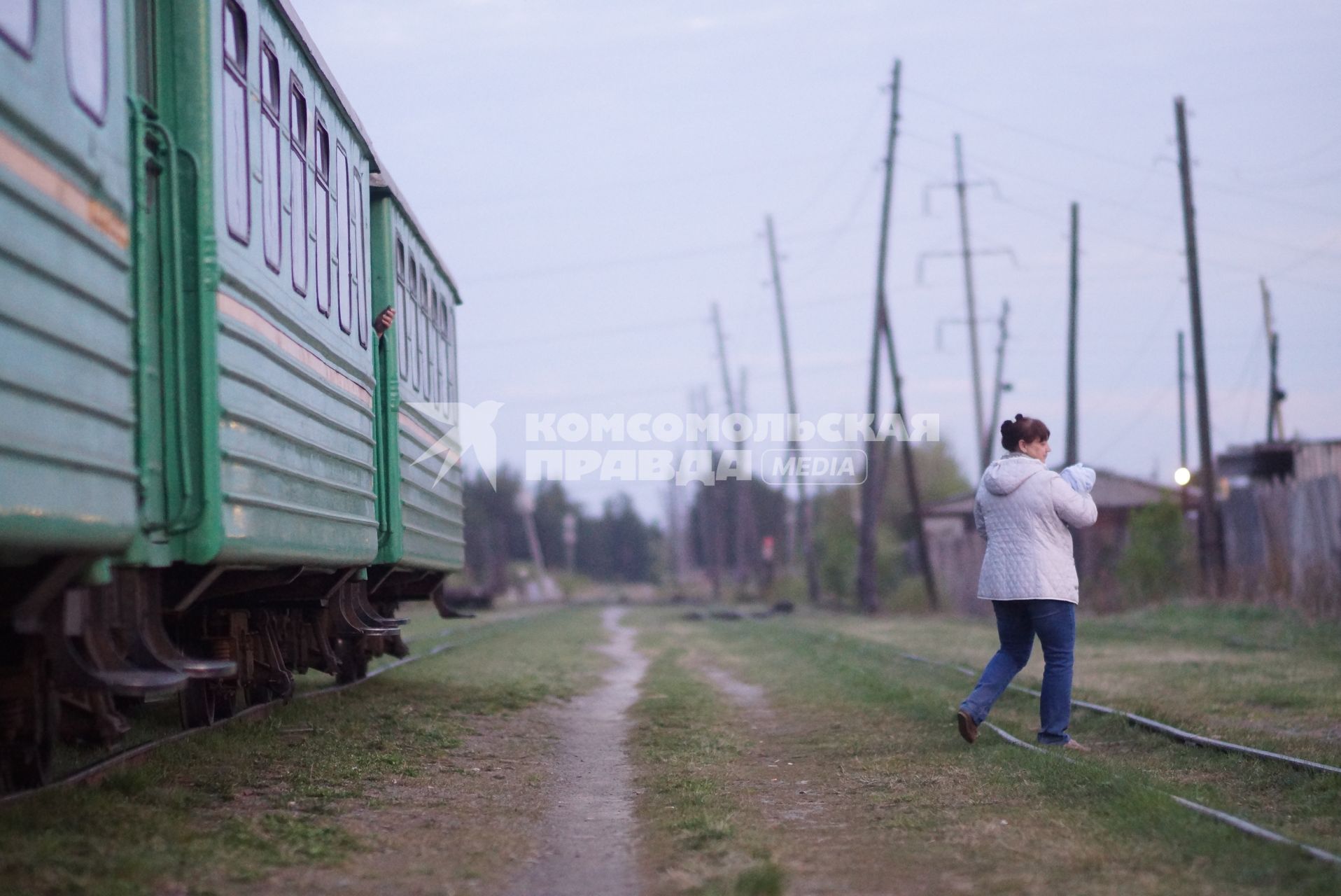 Женщина с грудным ребенком гуляет во время остановки поезда ст.Тимошина. По Алапаевской узкоколейной железной дороге, 1 раз в неделю по четвергам, на почтовом вагоне в составе пасажирского поезда доставляют почту, и продукты для магазинов в отдаленные деревни и села направлении поселка Махнево. Алапаевск