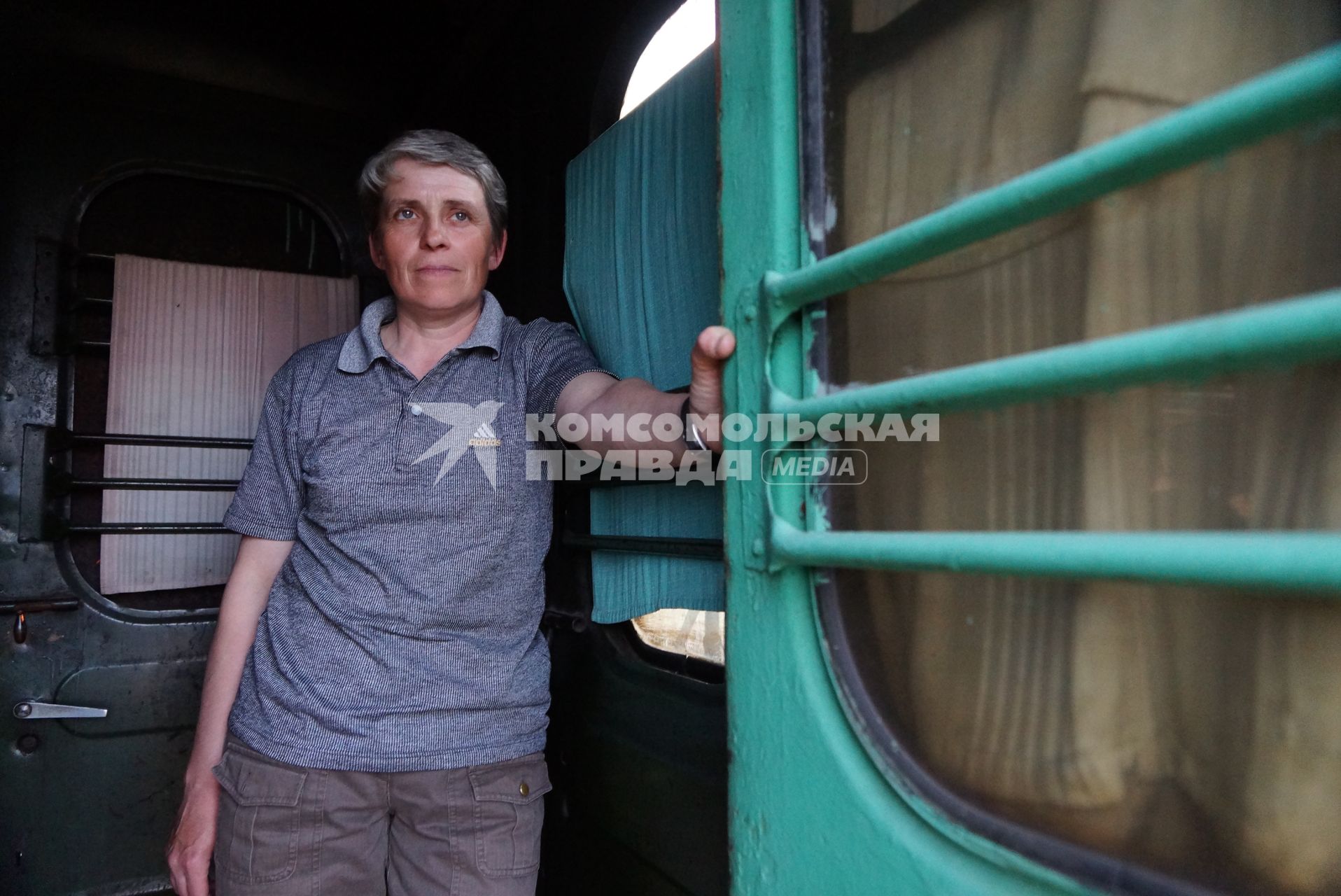 Начальник почтового вагона Юлия Шепелевич у открытой двери во время поездки. По Алапаевской узкоколейной железной дороге, 1 раз в неделю по четвергам, на почтовом вагоне в составе пасажирского поезда доставляют почту, и продукты для магазинов в отдаленные деревни и села направлении поселка Махнево. Алапаевск