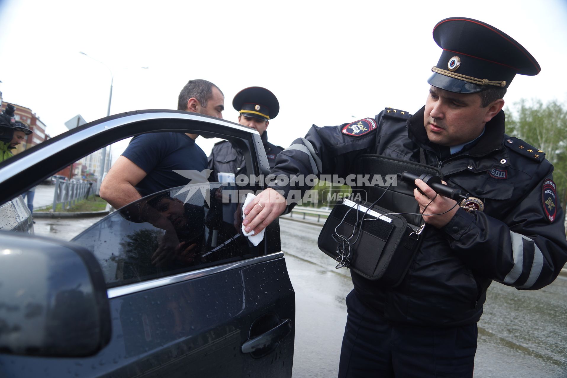 Полицейский ГИБДД с аппаратом  ИСС-1 (Измеритель светопропускания стекол), проверяет коэффициент светопропускания стекла во время рейда. Екатеринбург