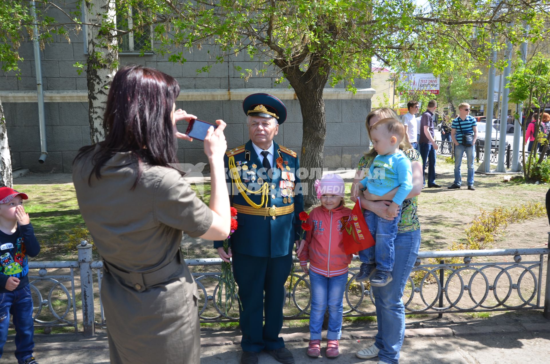 Новосибирск. Люди фотографируются с ветраном во время празднования 70-летия Победы в Великой Отечественной войне.