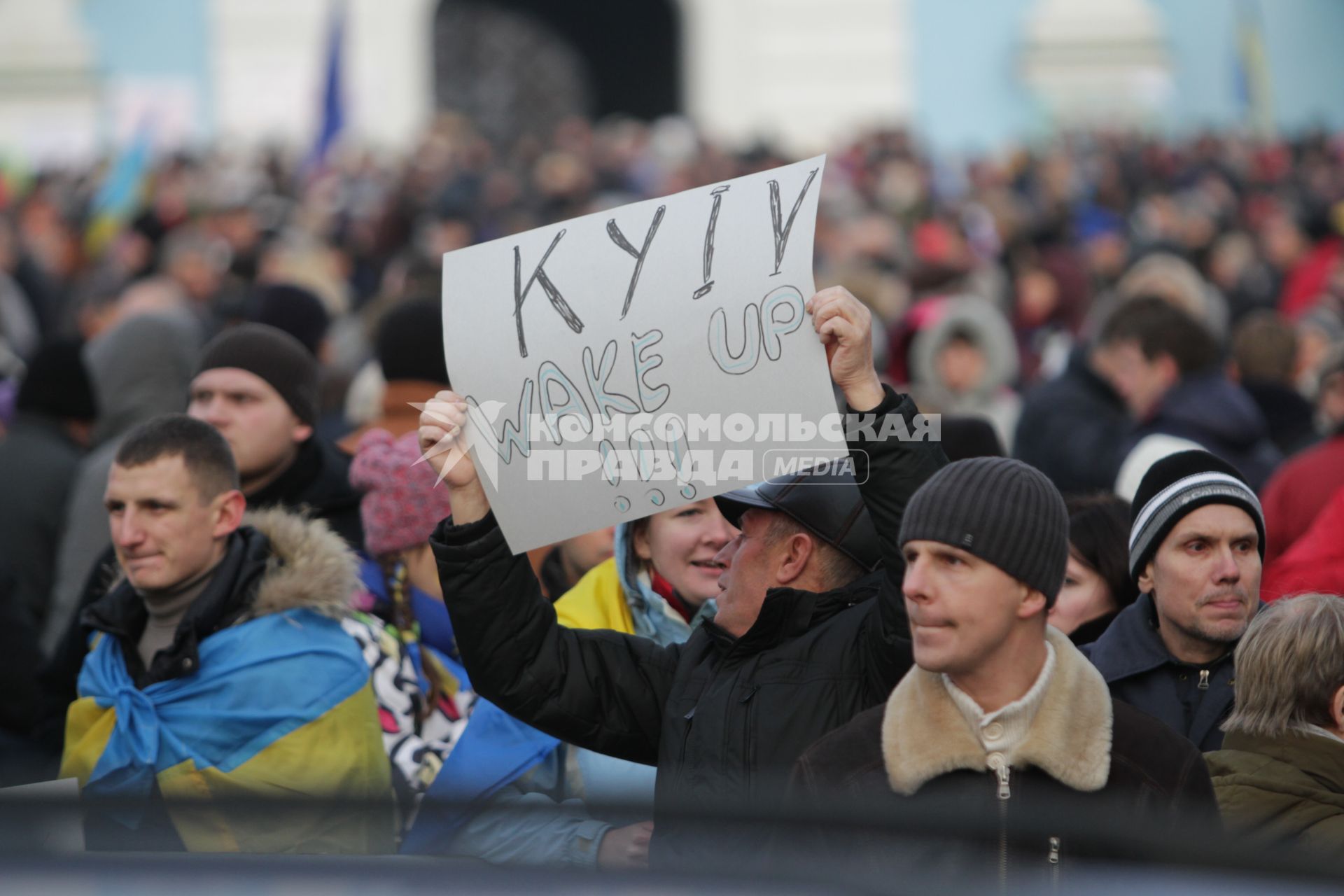 Киев. Акция сторонников Евроинтеграции Украины на Михайловской площади. Активист держит плакат `Киев, проснись!`.