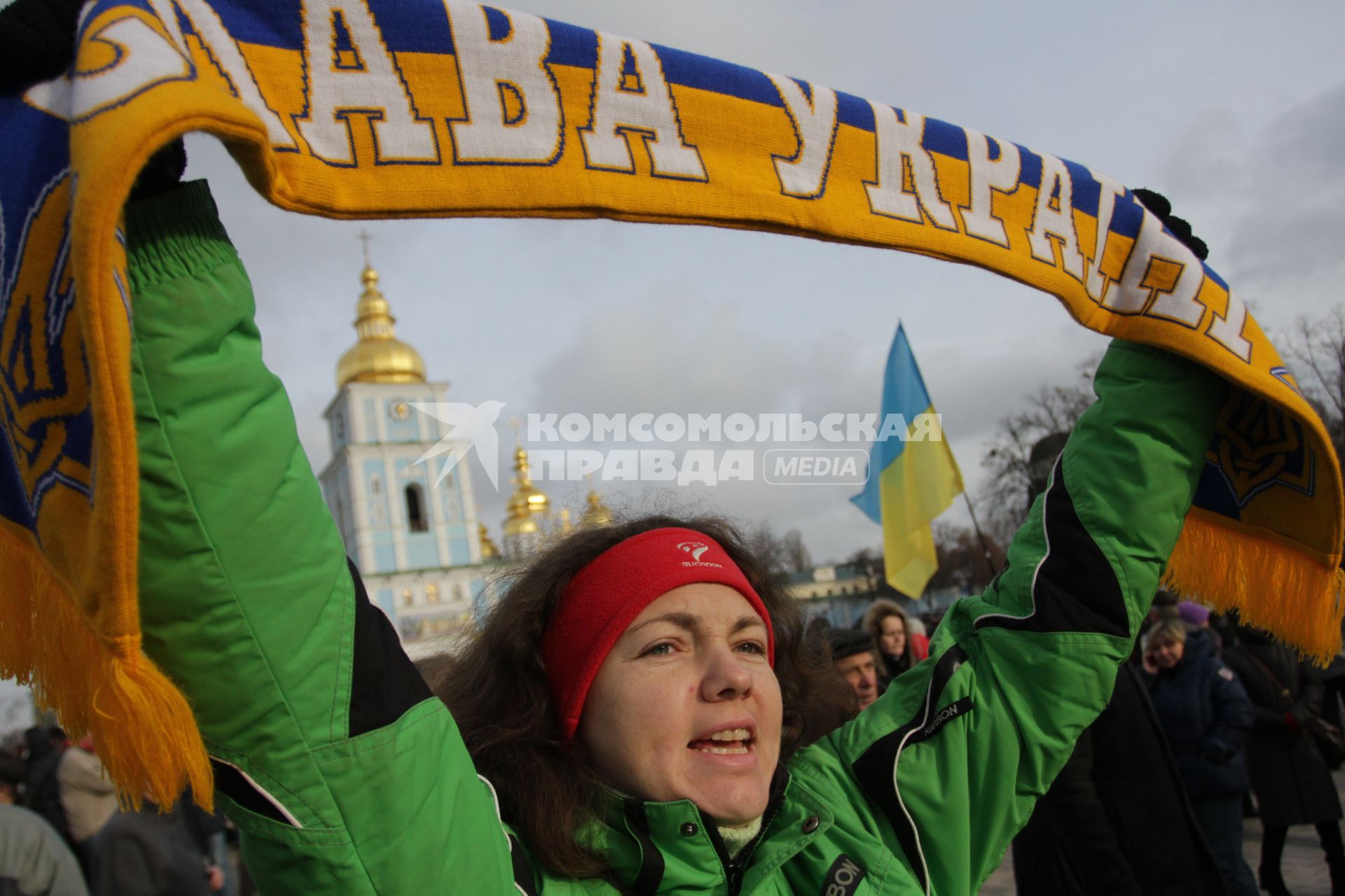 Киев. Акция сторонников Евроинтеграции Украины на Михайловской площади. Женщина держит шарф в цветах украинского флага. Надпись на шарфе `Слава Украине`.