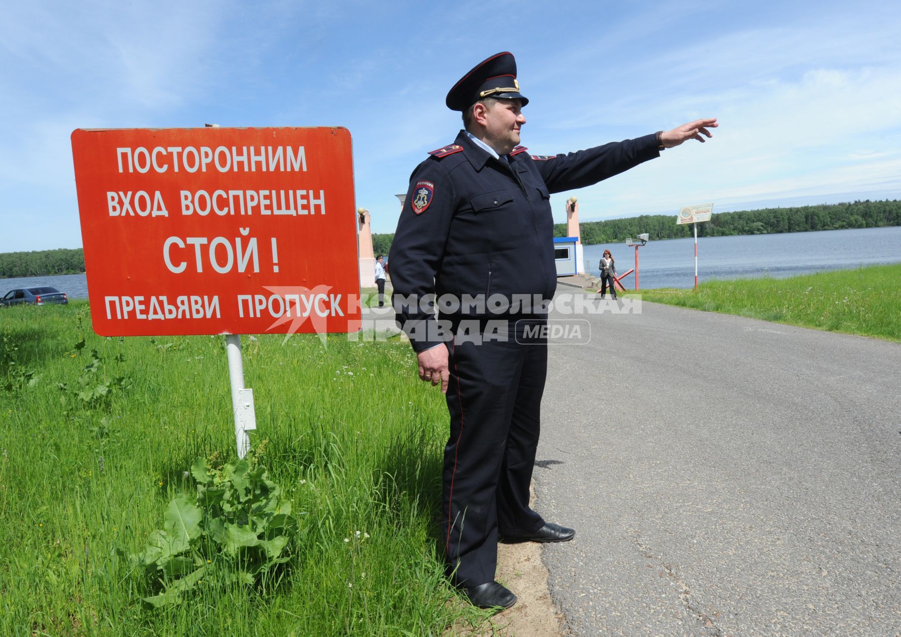 Московская область. Сотрудники полиции отрабатывают задержание преступников на Учинском (Акуловском) водохранилище. Полицейский стоит у таблички `Посторонним вход воспрещен. Стой! Предъяви пропуск`.