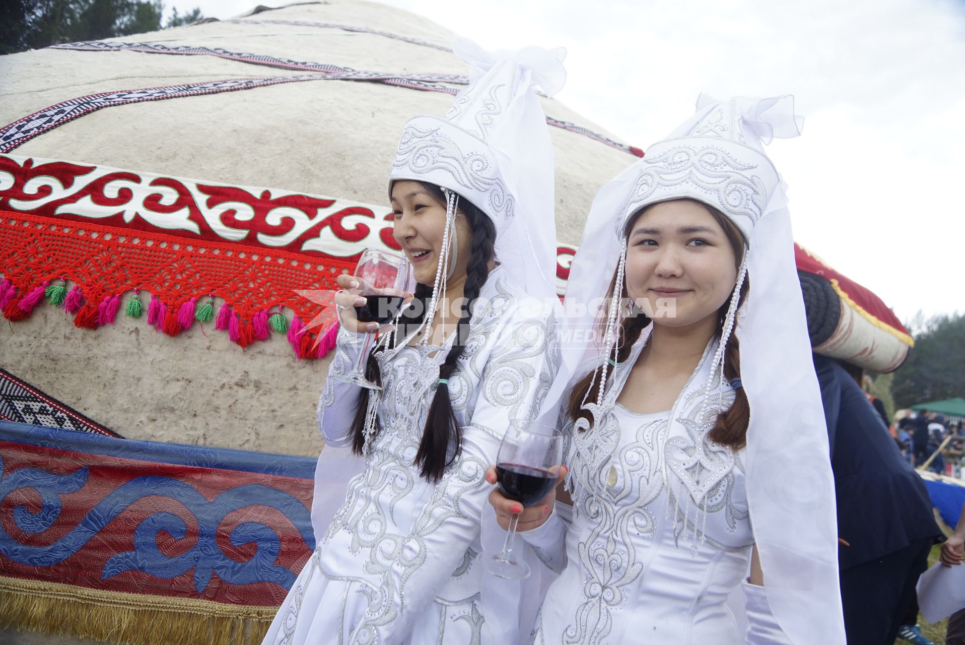 Девушки в национальном Башкирском свадебном наряде с бокалами вина, во время празднования Сабантуя. село Кадниово. Свердловская область