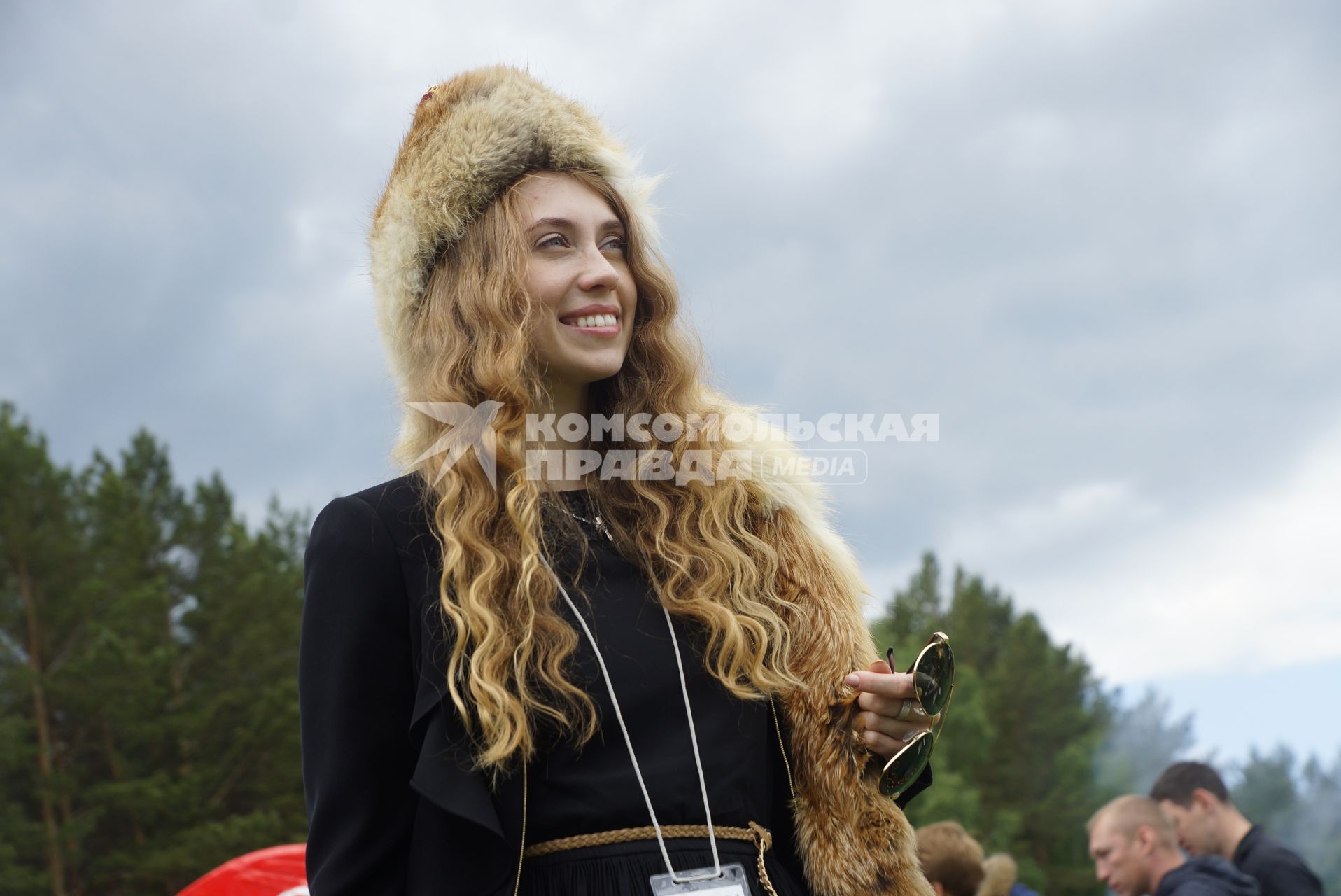 Девушка примеряет национальные башкирскую меховую шапку, во время празднования Сабантуя. село Кадниово. Свердловская область