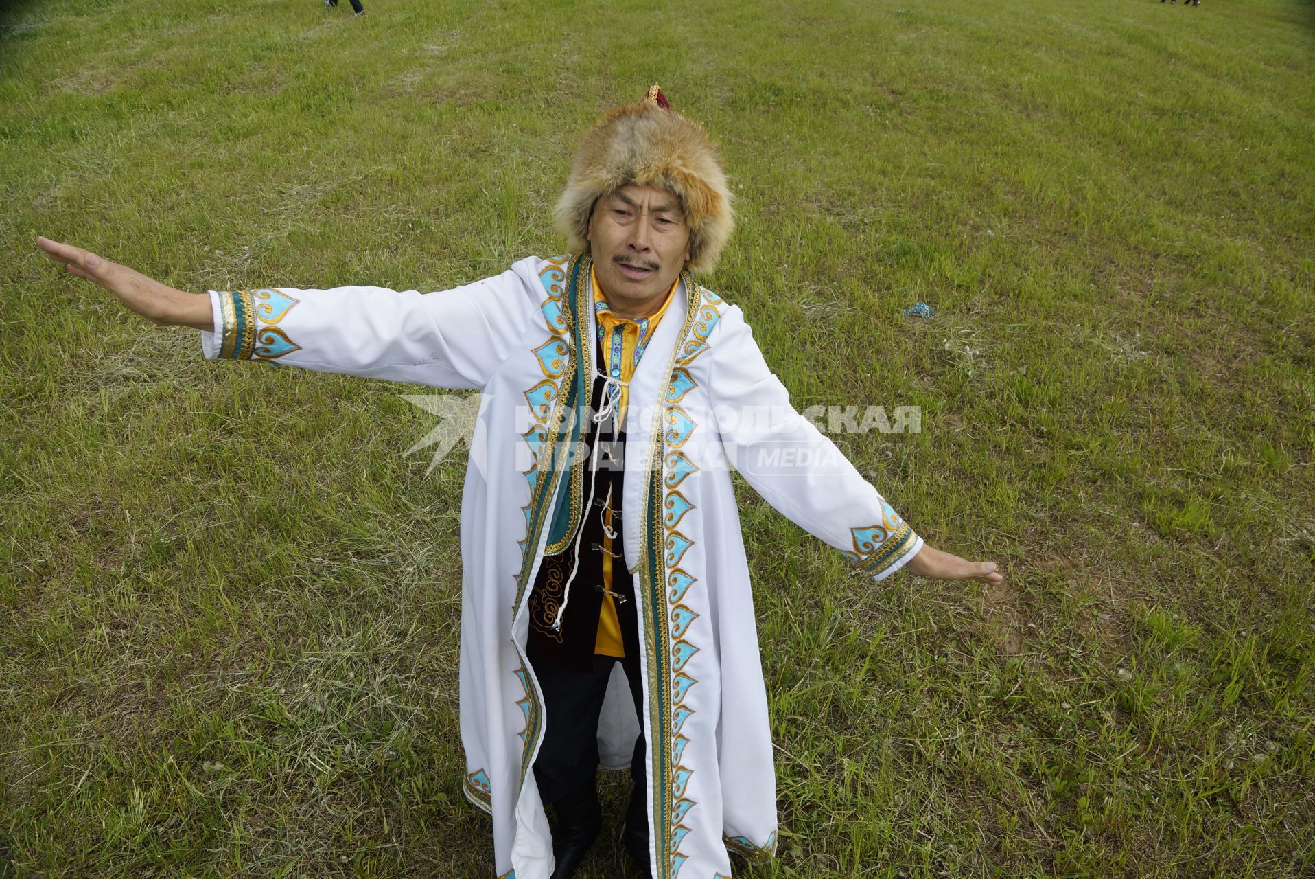 Мужчина в национальном Башкирском костюме танцует в поле, во время празднования Сабантуя. село Кадниово. Свердловская область