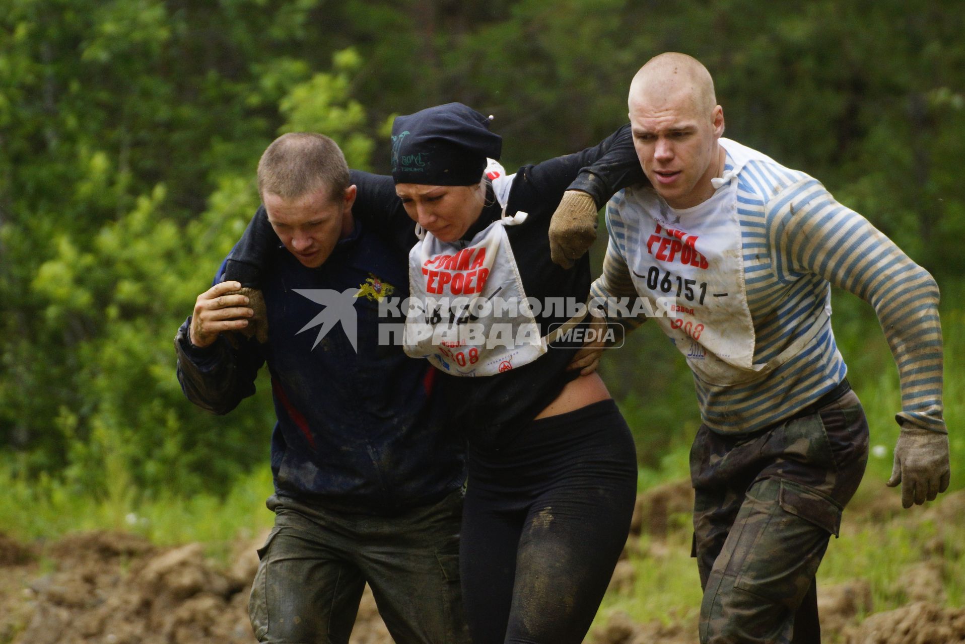 Участники военно-спортивной игры \"Гонка героев\", помогают травмировавшейся девушке, во время преодоления очередного препятствия. Танковый полигон 32-го военного городка. Екатеринбург