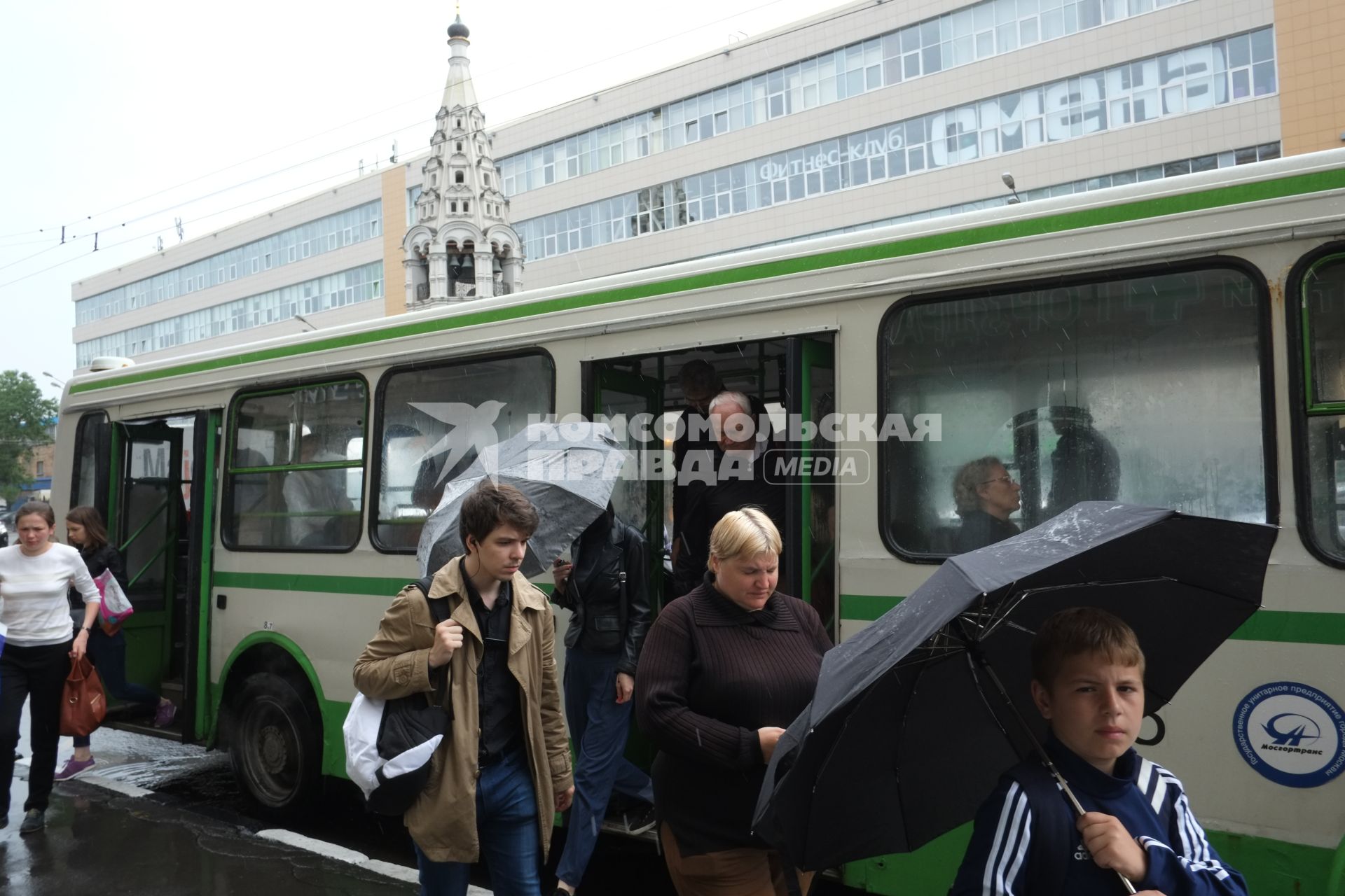 Проливной дождь в Москве. Пассажиры выходят из автобуса.