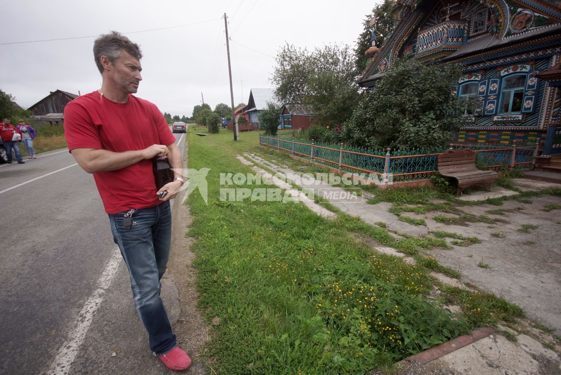 руководитель фонда \"город без наркотиков\" Евгений Ройзман несет банку варенья в подарок хозяйке живописного дома кузнеца Кириллова, в селе Кунара. Свердловская область