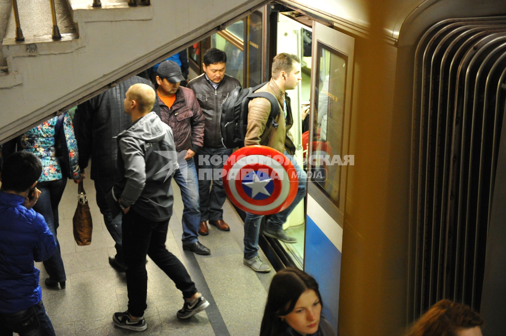 В Москве начали показывать фильм `Мстители: Эра Альтрона`. Мужчина со щитом `Капитана Америки` заходит в поезд на станции метро`Новослободская`.