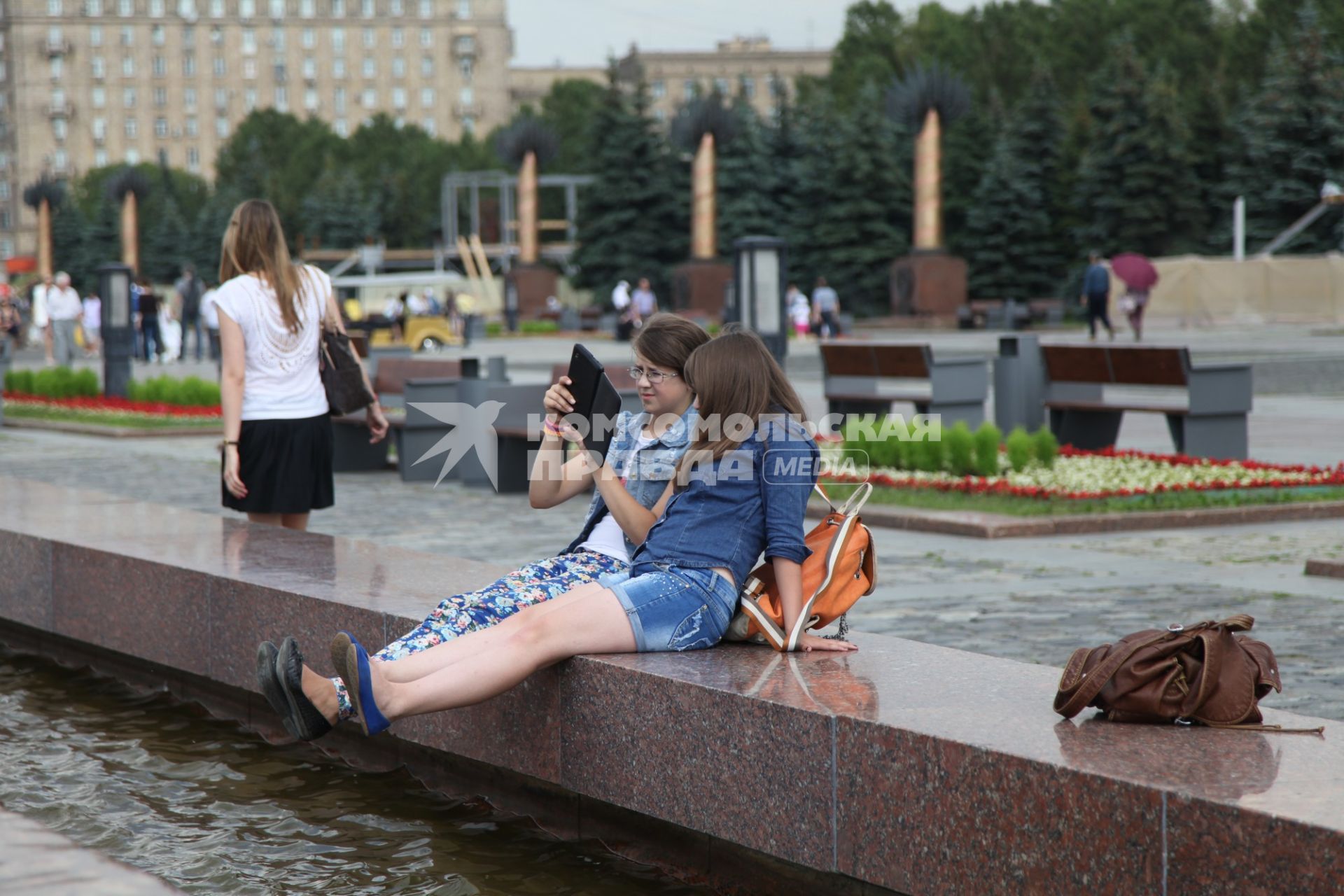 Москва. Девушки сидят у фонтана в Парке Победы.