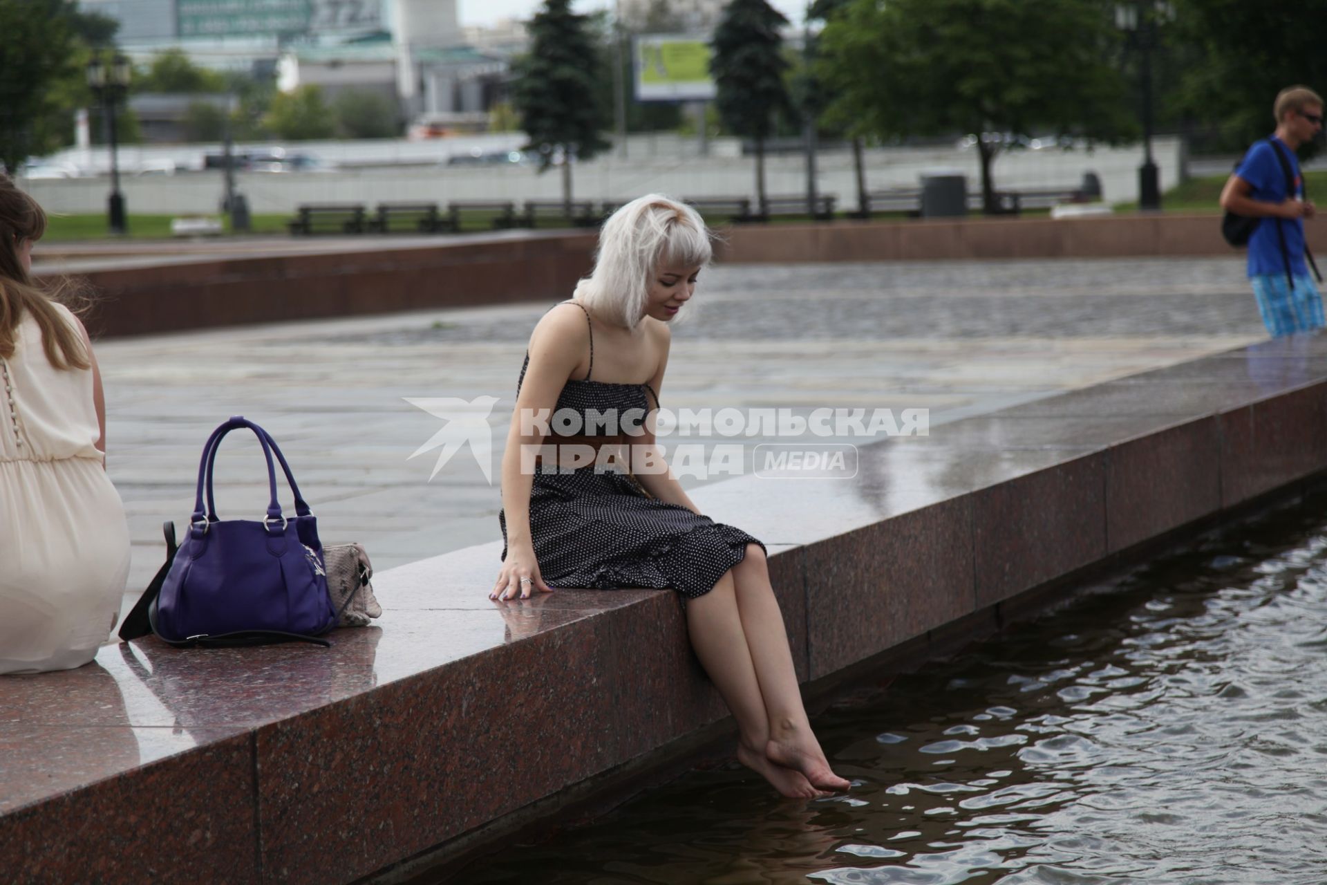 Москва. Девушка сидит у фонтана в Парке Победы.