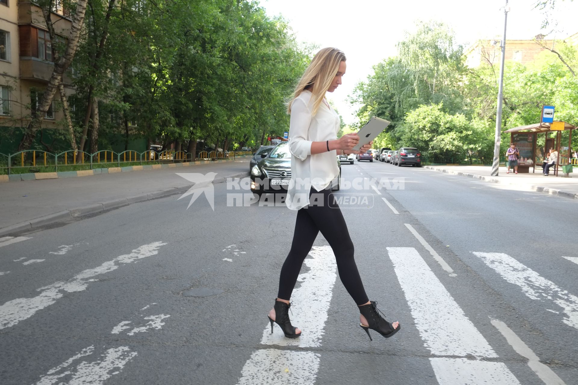 Москва. Девушка с планшетом в руках переходит дорогу