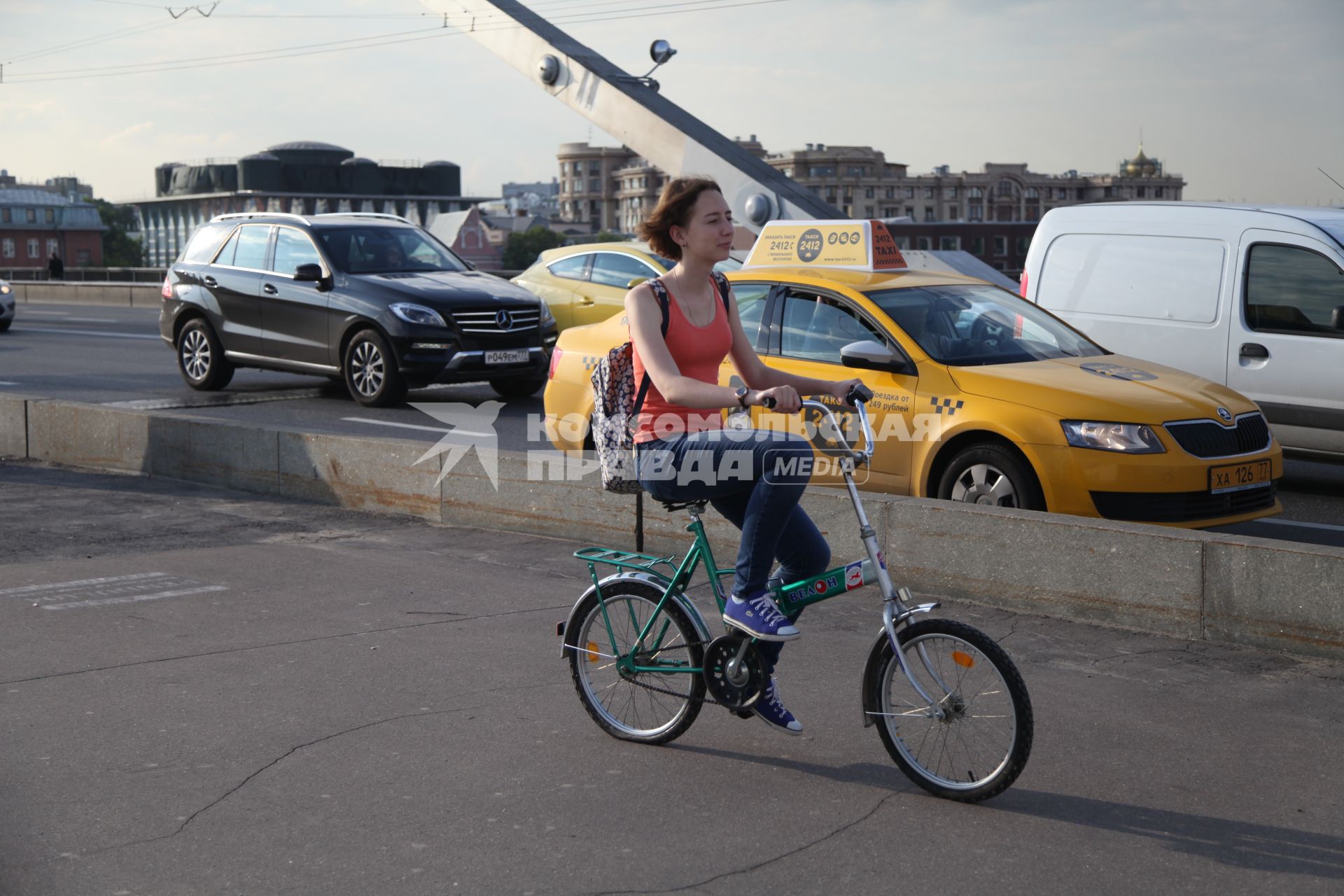 Москва. Девушка едет на велосипеде по Крымскому мосту.