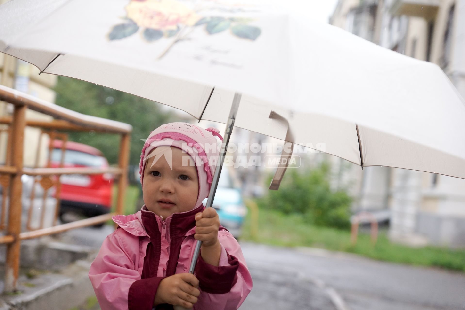 Маленький ребенок под зонтиком во время прогулки
