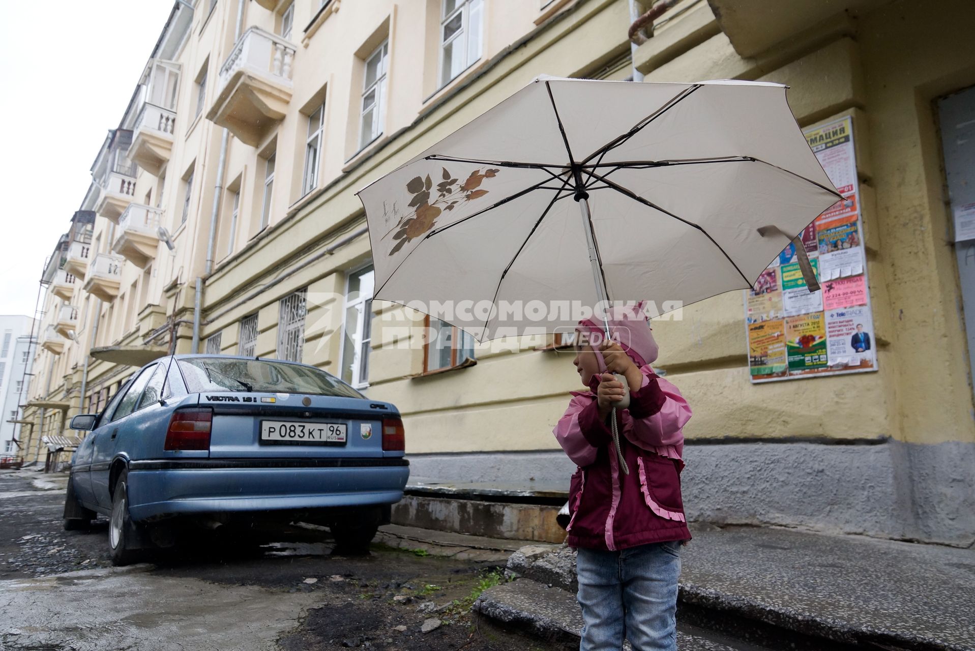 Маленький ребенок под зонтиком во время прогулки