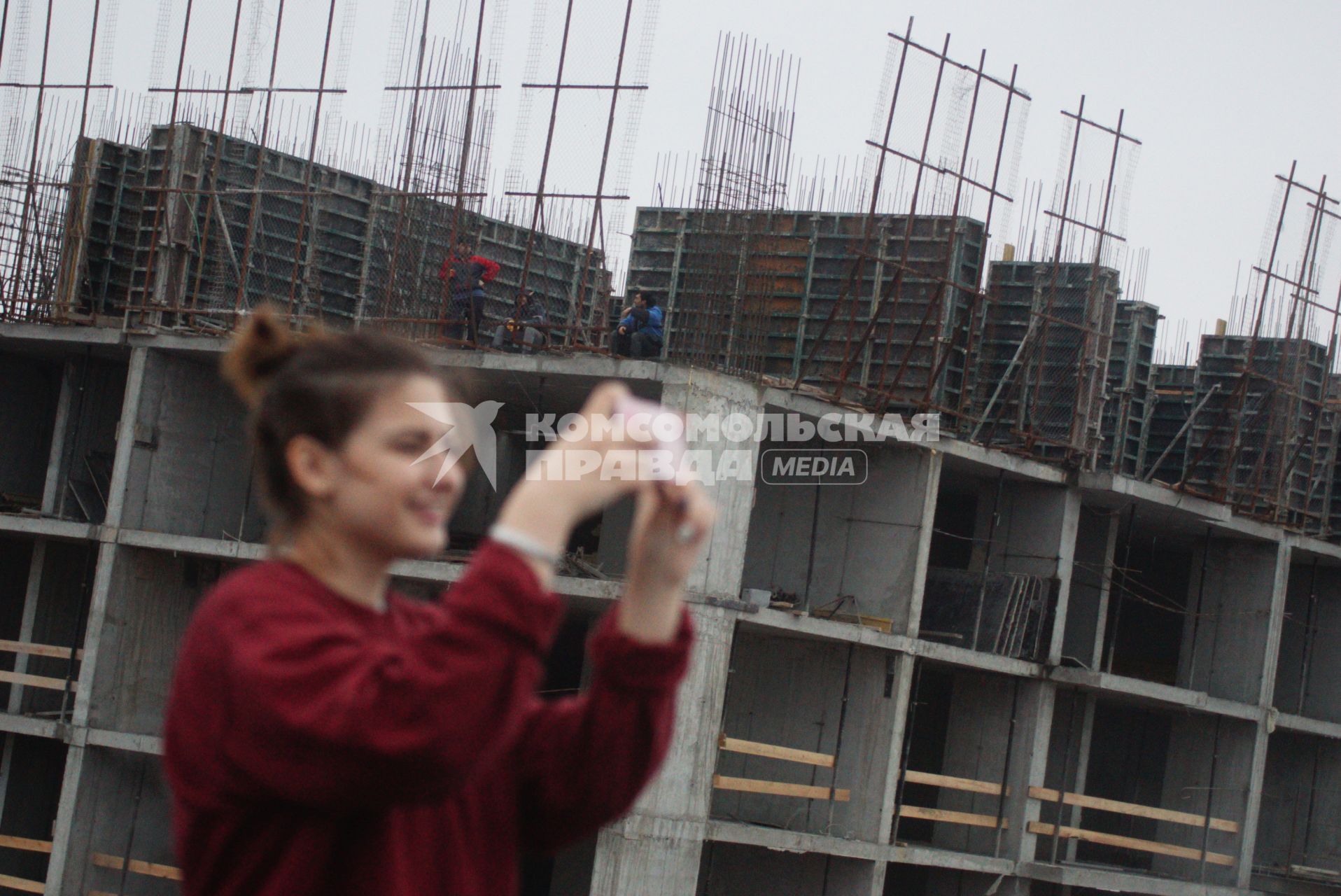 Строители с крыши соседнего строящегося здания наблюдают за фотографами снимающими виды города с крыши жилищного комплекса \"Малевич\", в рамках проекта Комсомольской правды \"Екатеринбург на высоте\". Екатеринбург