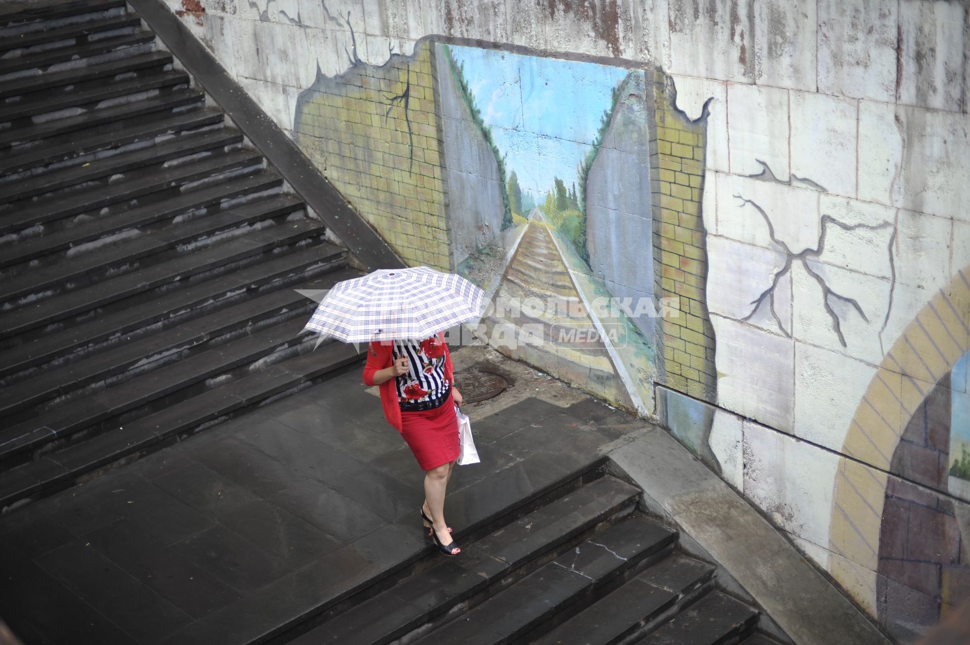 Армения, Ереван. Женщина под зонтом спускается по лестнице.